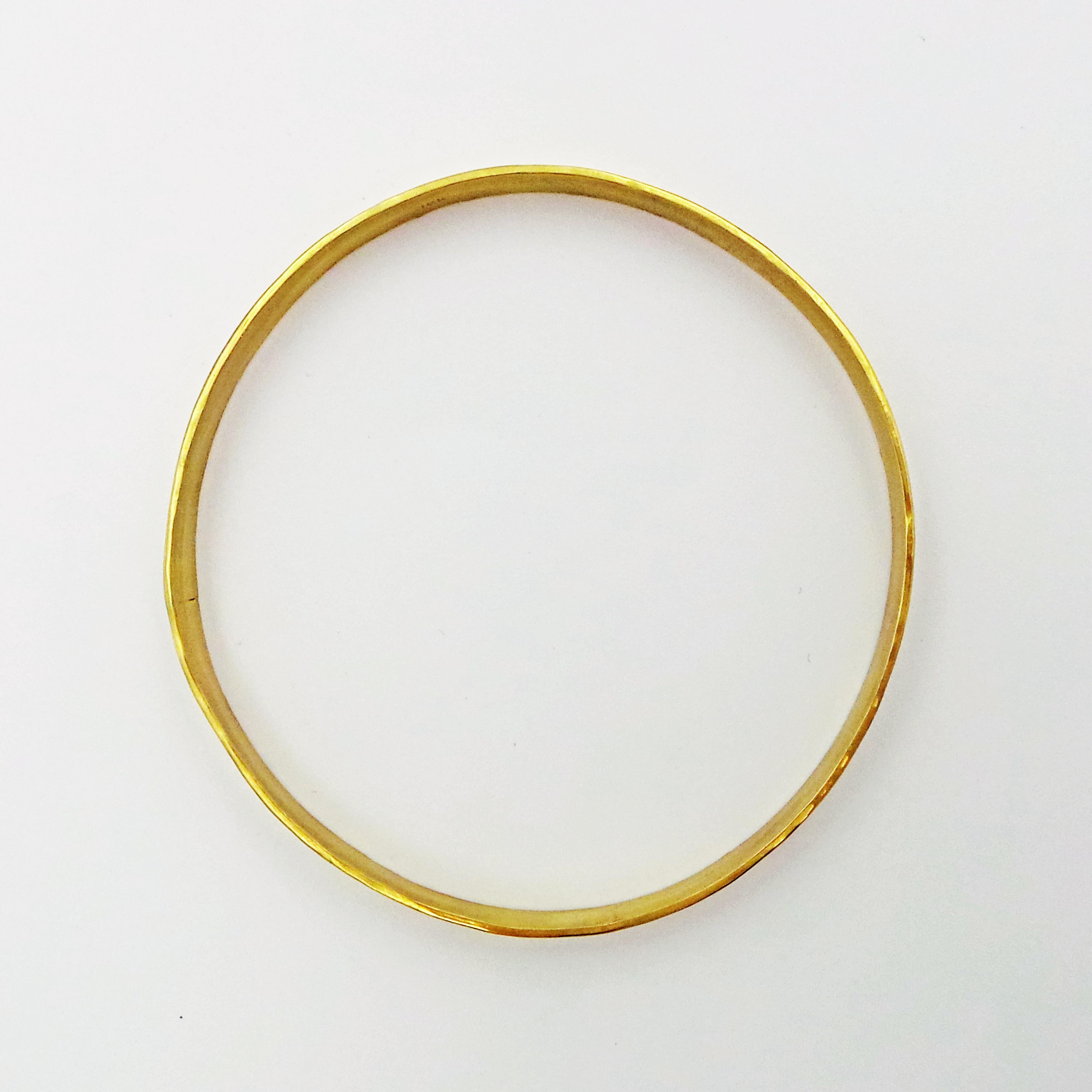 Solid 18k yellow gold bangle is hand-forged and finished with a hammered, rustic texture. Each bangle weighs 16.8 grams of gold. Bracelet is 2.5