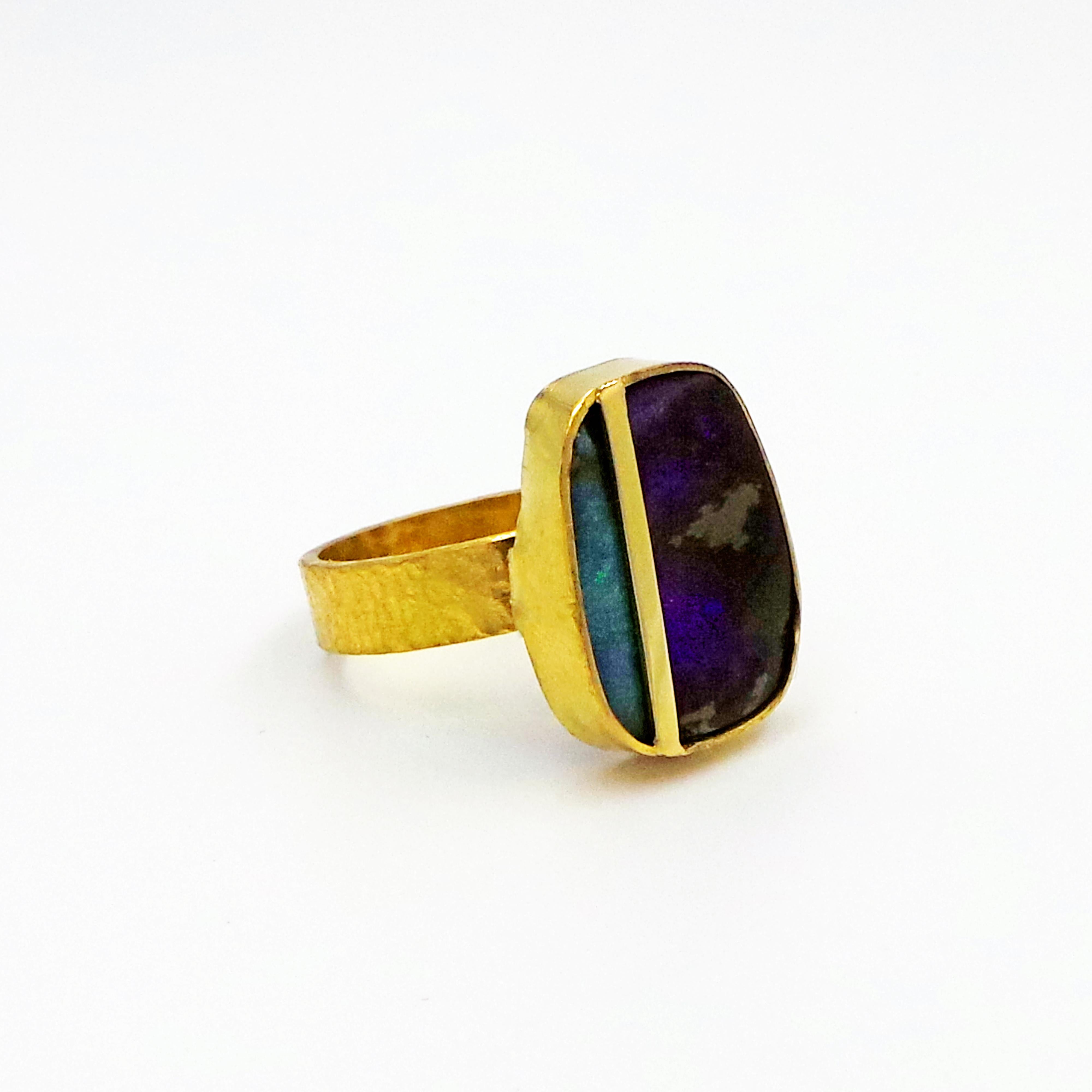 Hand- forged, solid 22k gold ring finished with a hammered, rustic texture. This beautiful Australian Boulder Opal has a natural separation of its green & blue coloration, which is accentuated with a gold bar set across the stone. Size 7. Minimalist