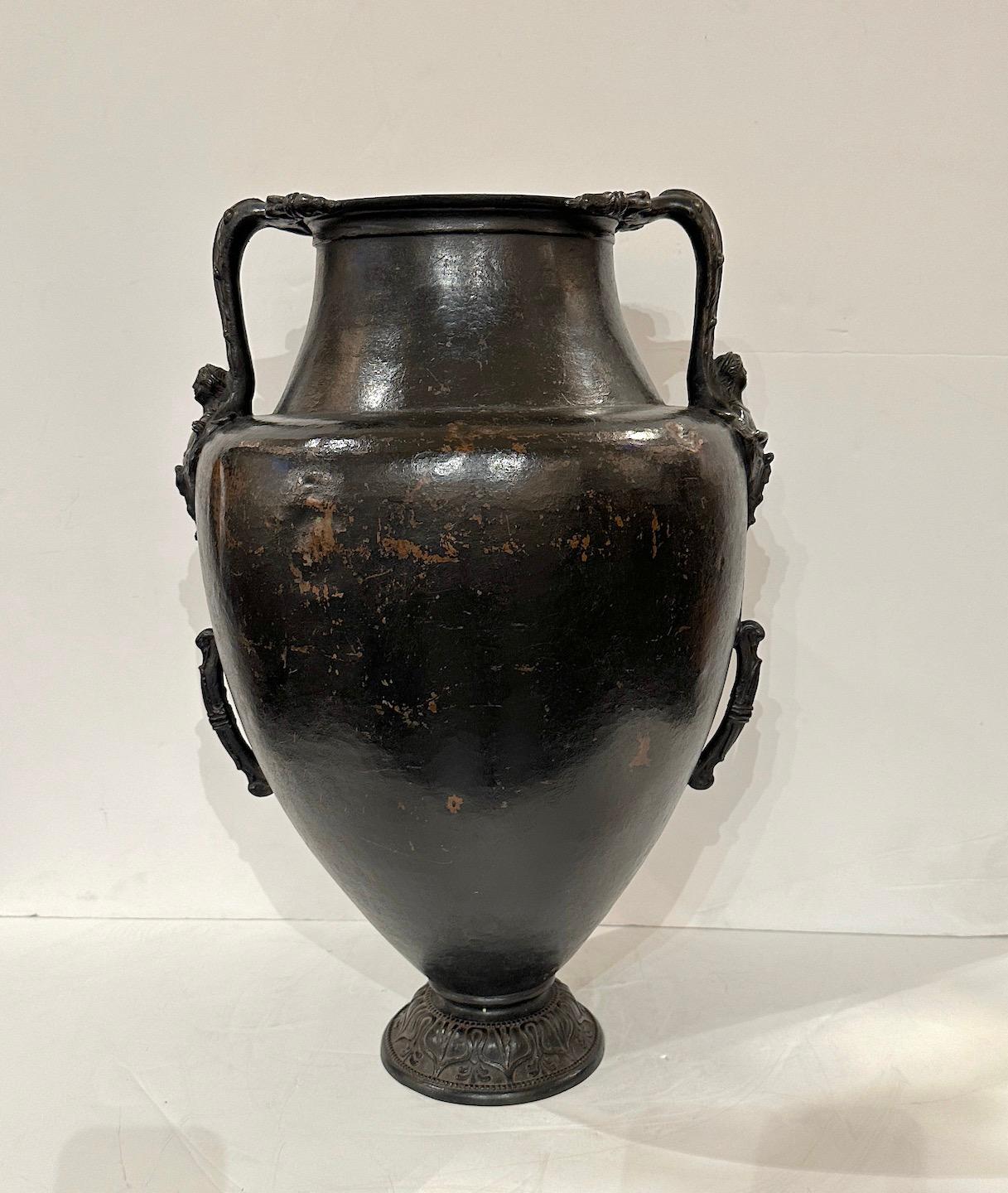 Hand forged bronze urn with figural handles and incised base.