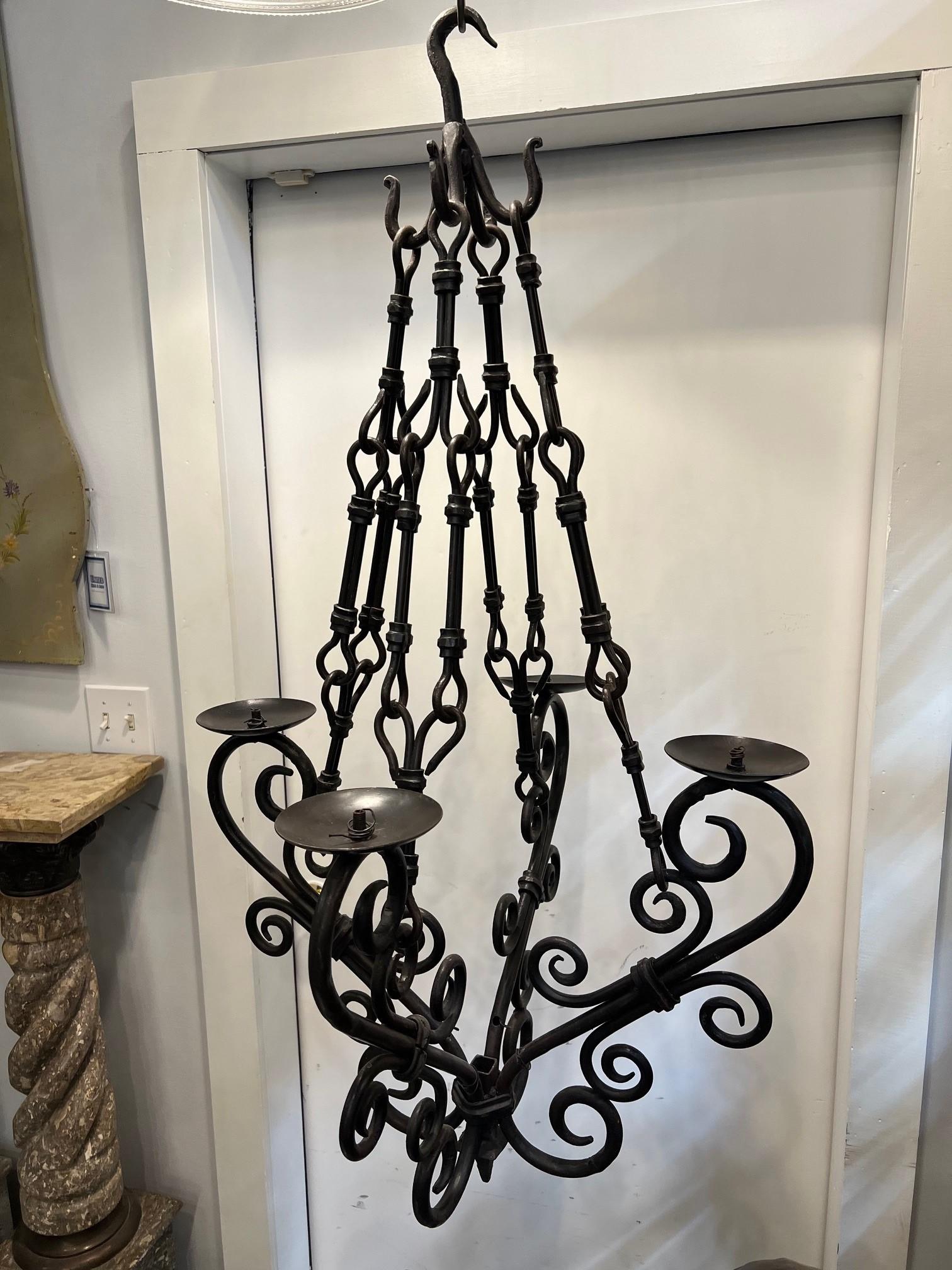 Beautiful decorative iron chandelier with four lights ready to be wired. Hand forged with curved arms and scrollwork, hanging from four hand forged bars attached to a large hook. It's a nice size and would look great in a kitchen or hanging in a