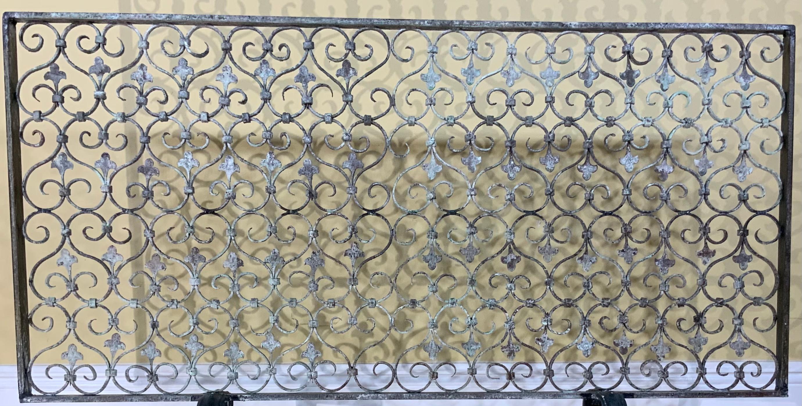 Beautiful fireplace screen made of hand forged iron with decorative repeated motifs of scrolls and three leaves
Originally it was gate in a Palm beach old estate and was salvage to become exceptional fireplace screen. Fireplace screen is treated