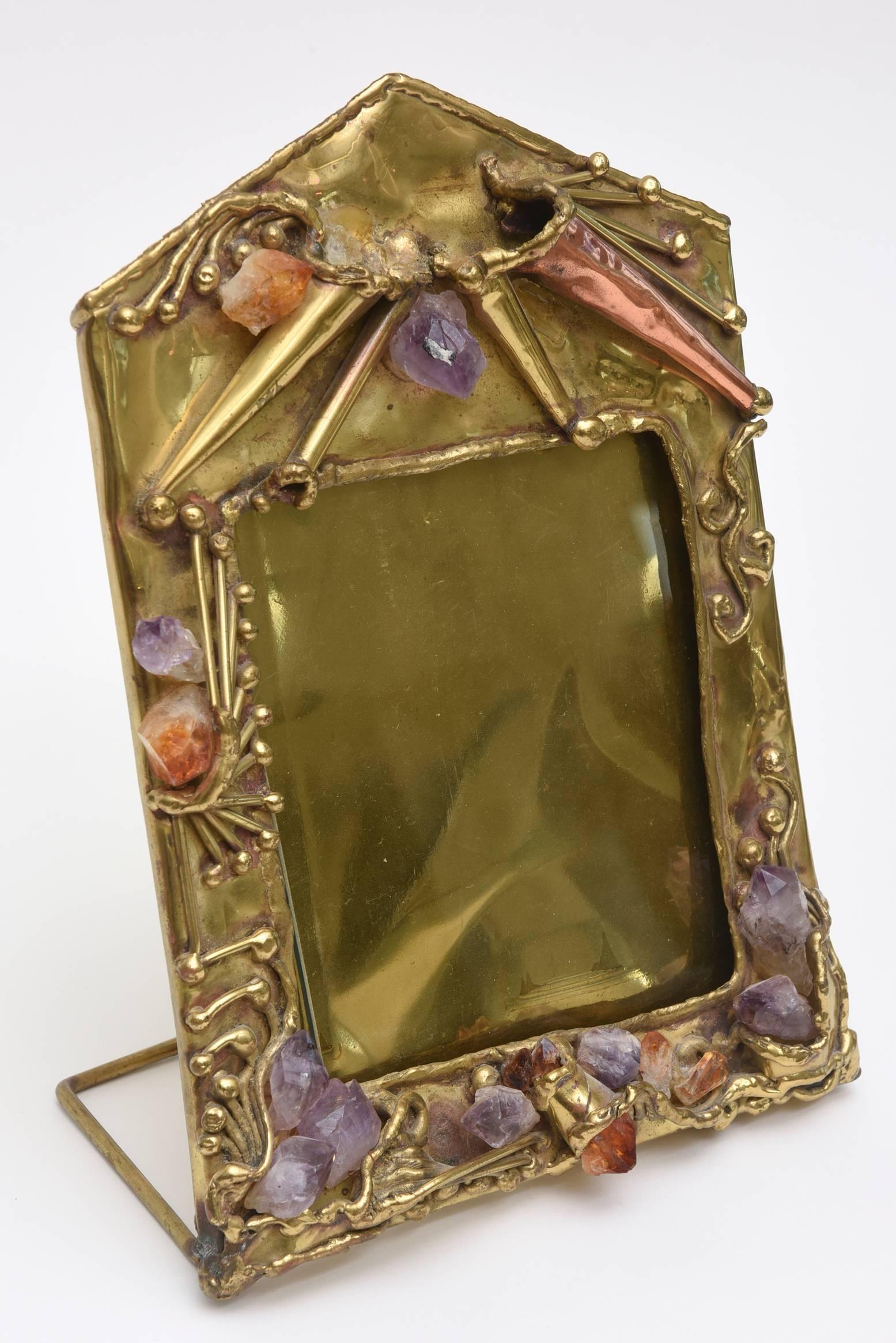 This beautiful combination of hand forged brass mixed with copper elements and protrusions of chunks of amethyst rose quartz and quartz picture frame is one of a kind. It is vintage and from the 1970s. It has a sculptural entity to it. Please note