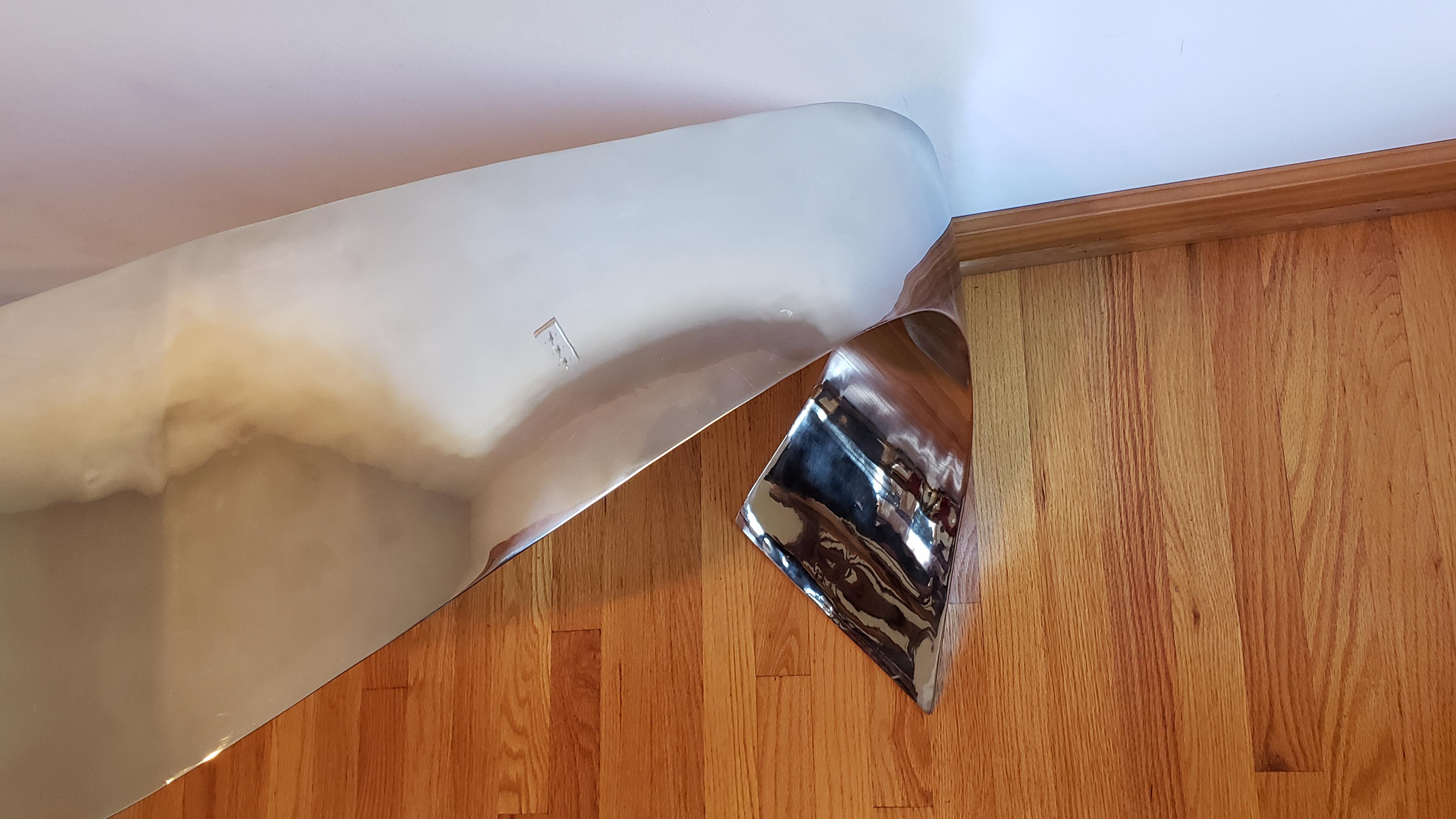 Lujosa y etérea consola de acero inoxidable forjado a mano de Curtis Norton Sculptural. De aspecto casi ingrávido en persona, con una superficie pulida casi como un espejo, en ciertos ángulos los reflejos hacen que la consola parezca flotar en su