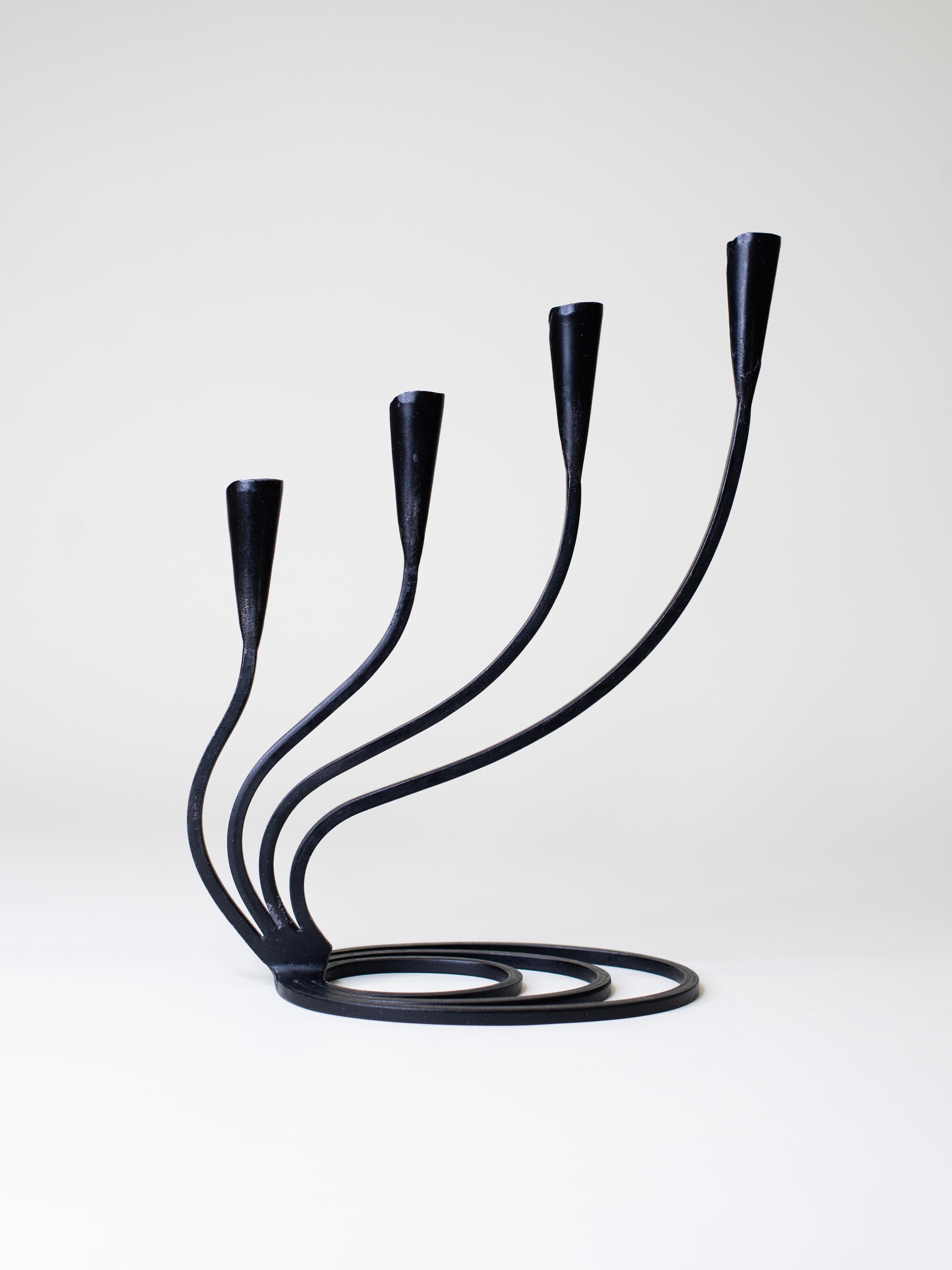 A Swedish wrought iron candelabra from the 1940. Hand-forged with a spiral base and four curved arms, this piece blends Scandinavian Modern elegance with a raw, Brutalist edge. Both functional and sculptural, it brings character to any
