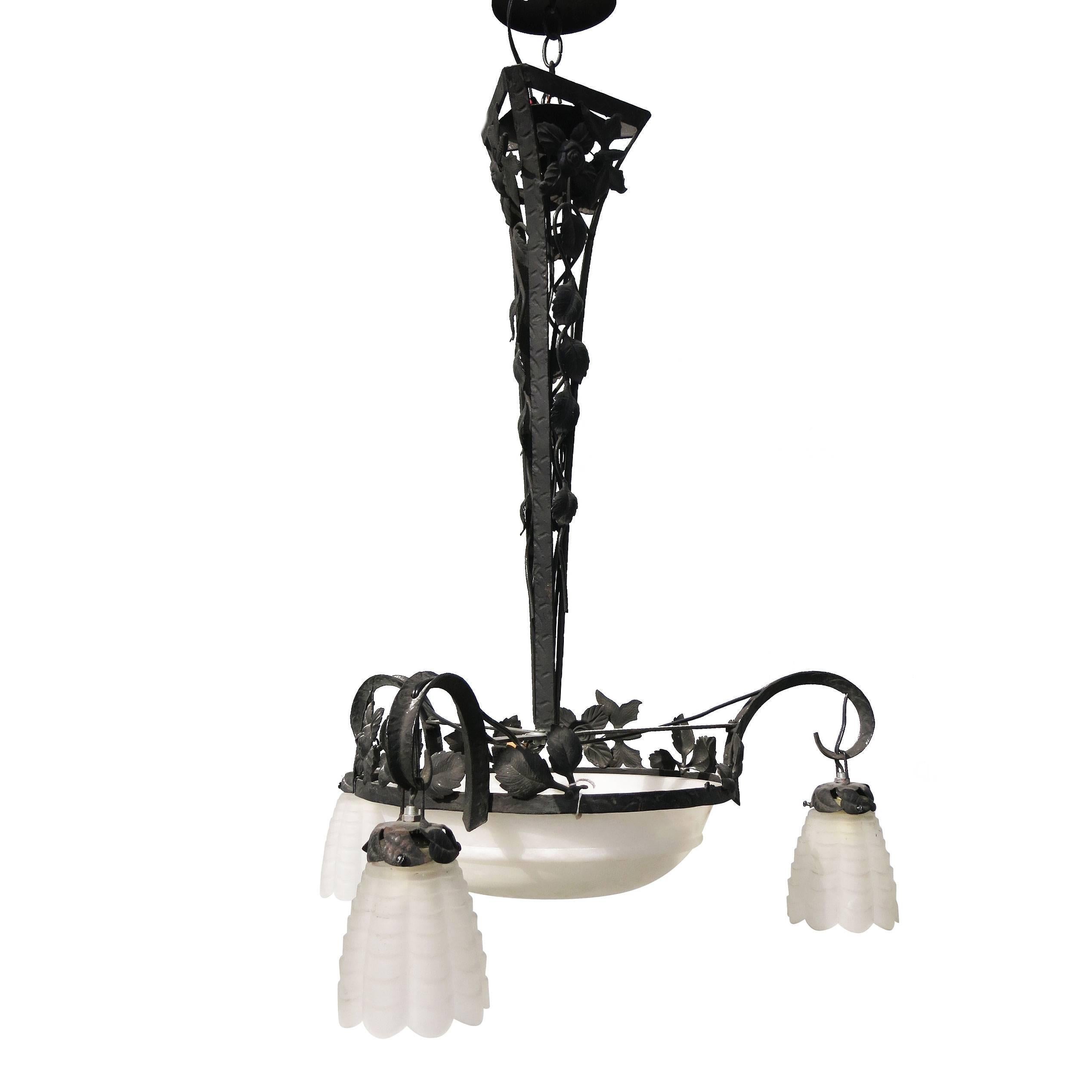 Hand forged tole French style alabaster and iron chandelier with hand forged black iron chandelier and hand carved alabaster shades. The chandelier features a large light up dome shade in the center and three hand carved alabaster shades.

Sold