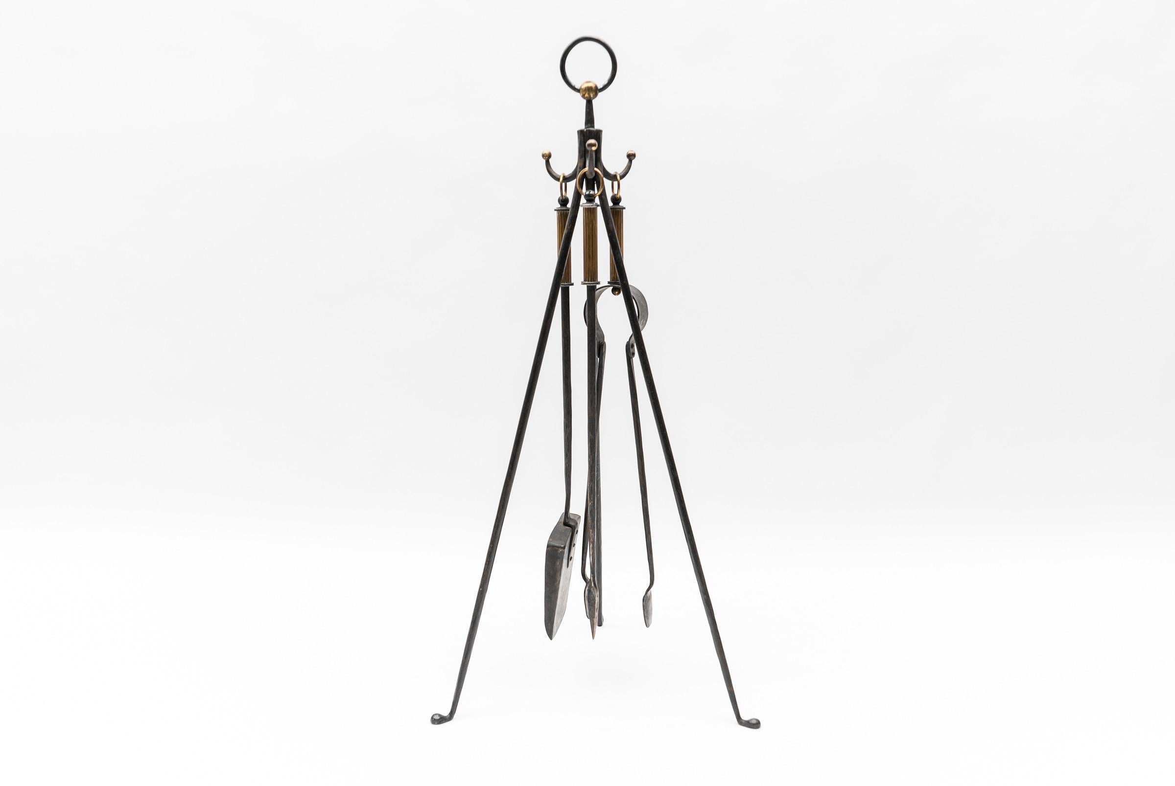 Hand forged tripod iron and brass stand with fireplace tools, Austria 1950s.

Highest quality. Extremely rare and never seen before in such a delicate and coordinated form. 

A real eye-catcher.