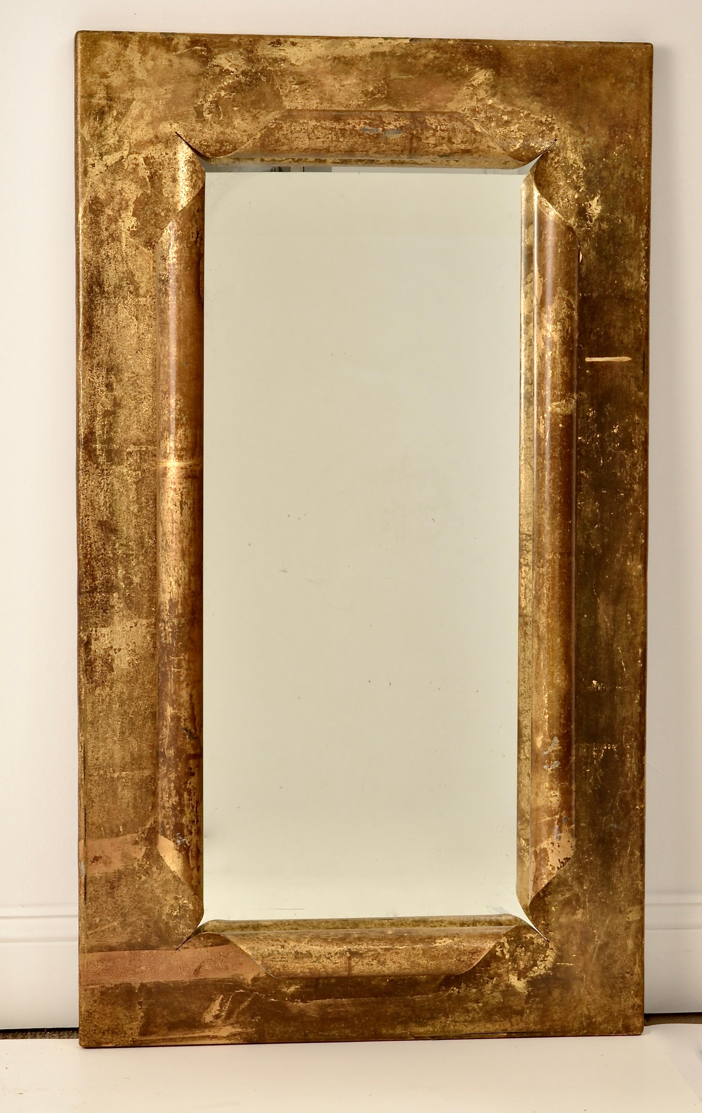 Great architectural form on this steel mirror with curled edge decoration. Hand applied antiqued gilding. Substantial, fine quality.