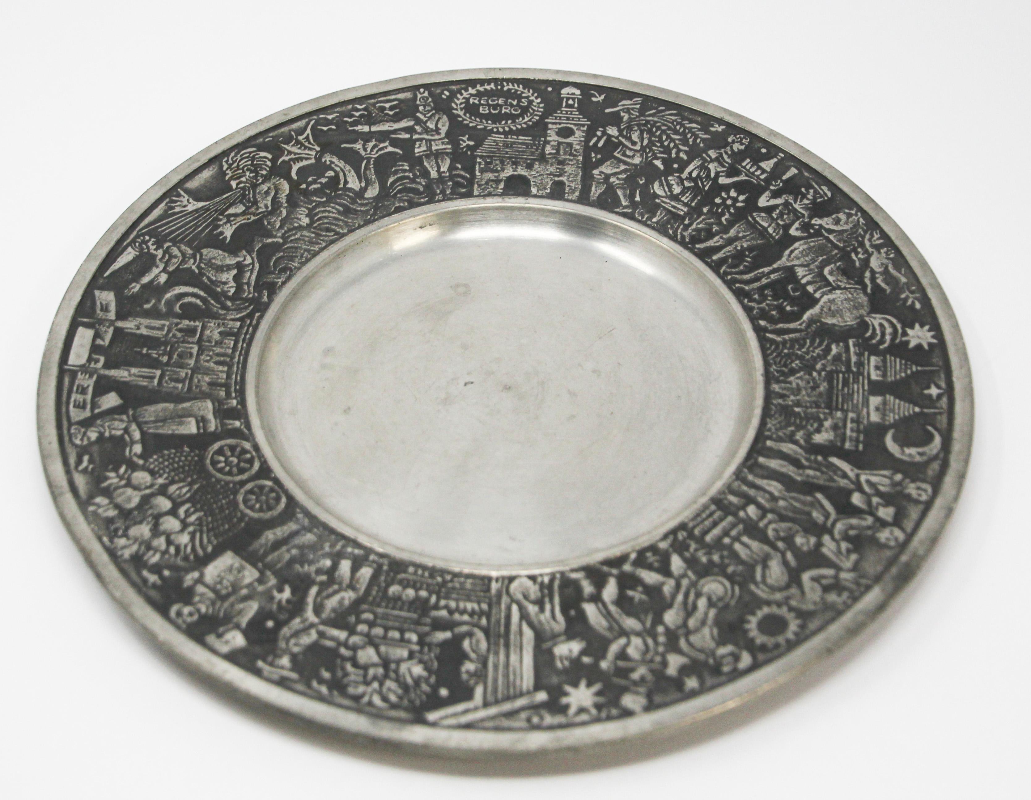 Heavy handcrafted metal pewter plate with design of scenes from early 20th century depicting the city life of Regensburg in Germany.
People, dog, horse, architectural buildings.
Handcrafted in West Germany relief decorative circular tray with