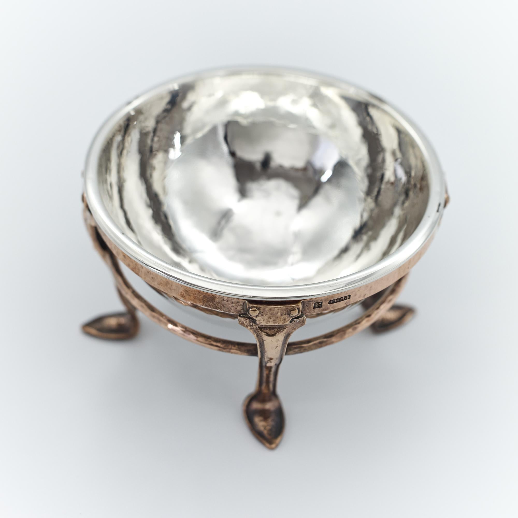 Un'interessante ciotola d'argento Arts & Crafts martellata a mano con cornice in rame fatta a mano, di epoca edoardiana. Sia la ciotola che la base in argento sono martellate a mano.

Un bellissimo e decorativo esempio dello stile Decorative Crafts,