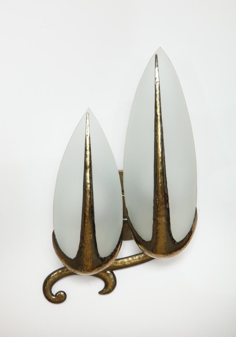 Hand-Hammered Brass and Opaline Sconce, Italy, c. 1940

Poetic, art-nouveau style sconces with beautifully patinated brass and cast opaline glass which throws light beautifully. Elegant scroll detailing at the bottom of the lamp.

