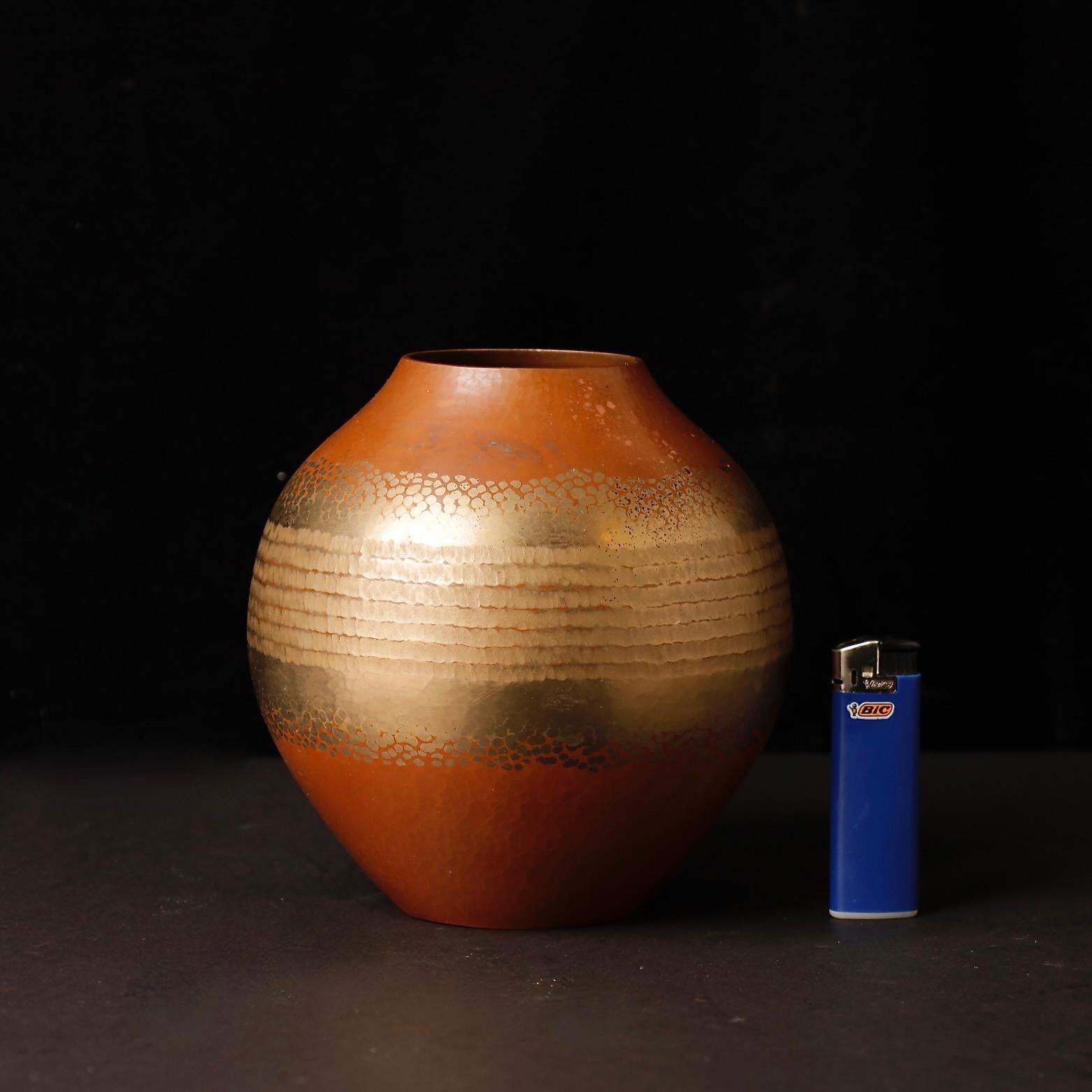 Un bellissimo vaso in rame martellato a mano realizzato dal rinomato laboratorio giapponese Gyokusendō, famoso per la sua maestria nella lavorazione del rame Tsuiki (槌起), una tecnica tradizionale con oltre 200 anni di storia.

Originario della città