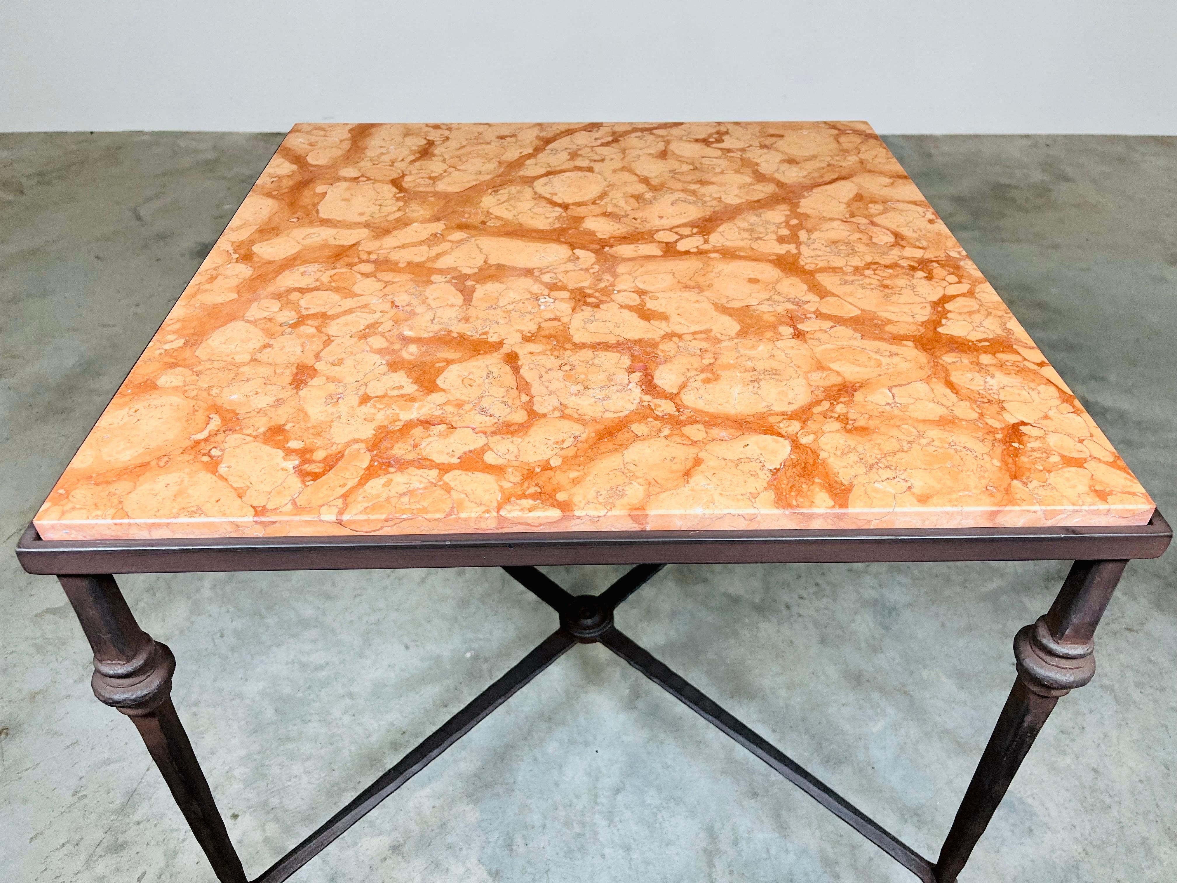 An elegant occasional table in the manner of Maison Baguès having hand hammered iron base with Marmo Rosa del Garda marble top. Italy Circa 1960. In exquisite condition having chip/crack free marble and perfect base. 
23.5 x 24.25 x 24.25” HWD.