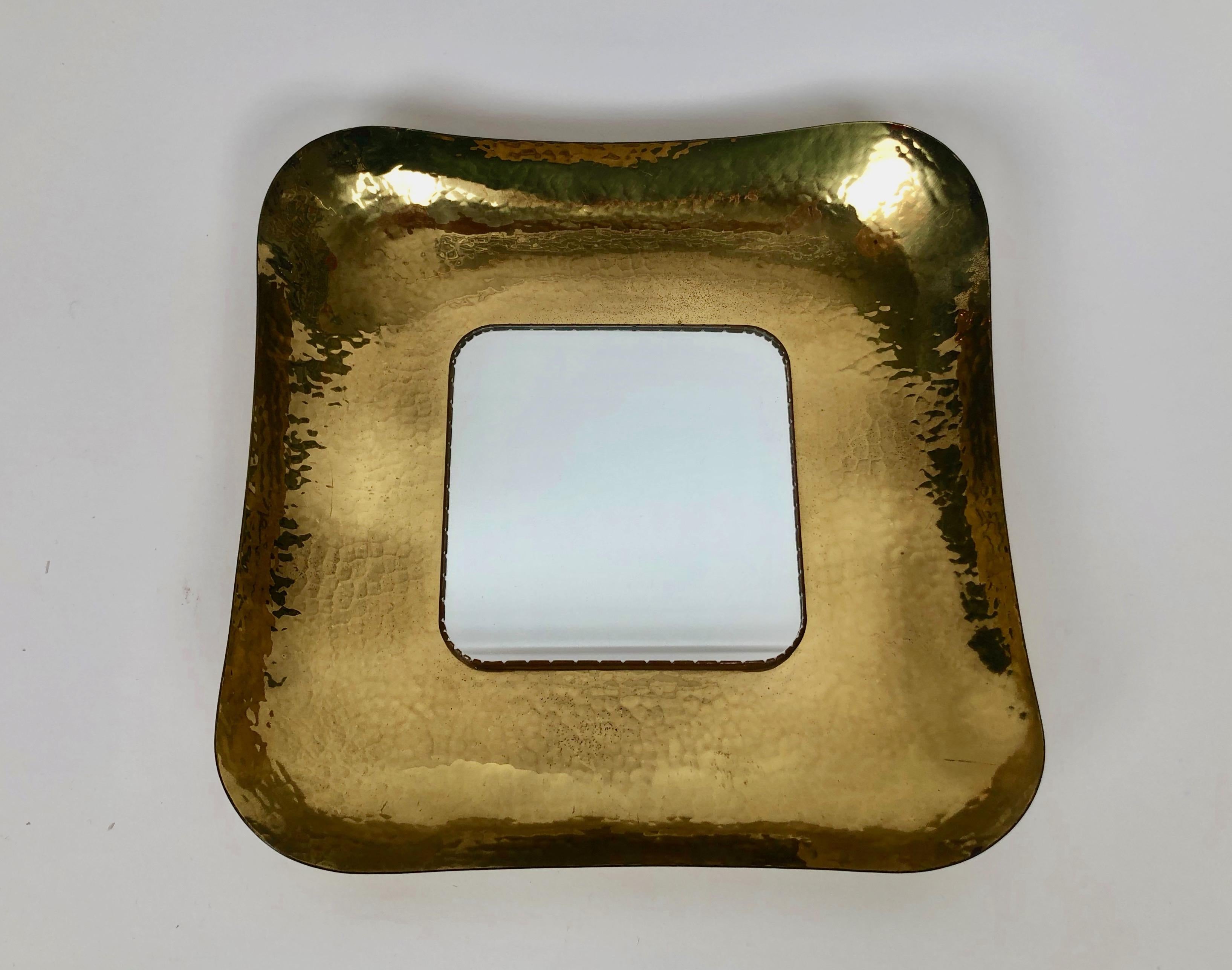 An exquisite hand hammered mid-century brass mirror made by Austrian craftsmen,
in the 1950's. The excellent hand work that went in to forming the brass is typical 
of high end craftsmanship that we expect from Austrian artisans . The mirror is held