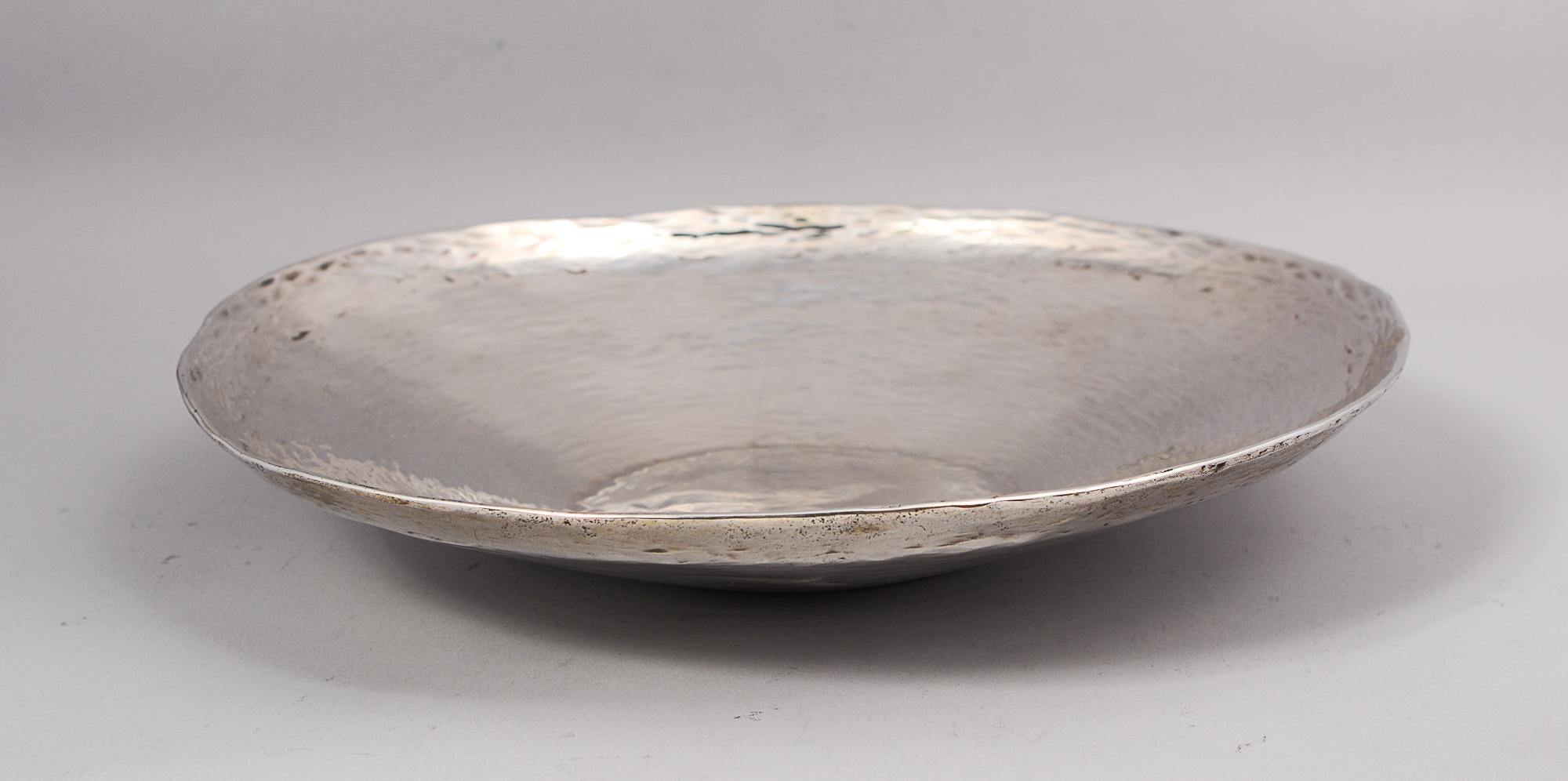 Hand hammered sterling silver bowl by Industria Peruana. The bowl is marked with the makers name J. Tovara. The sides of the bowl have a ripples in water feel. The rim is uneven giving it even more of a handmade look. There is one long scratch on