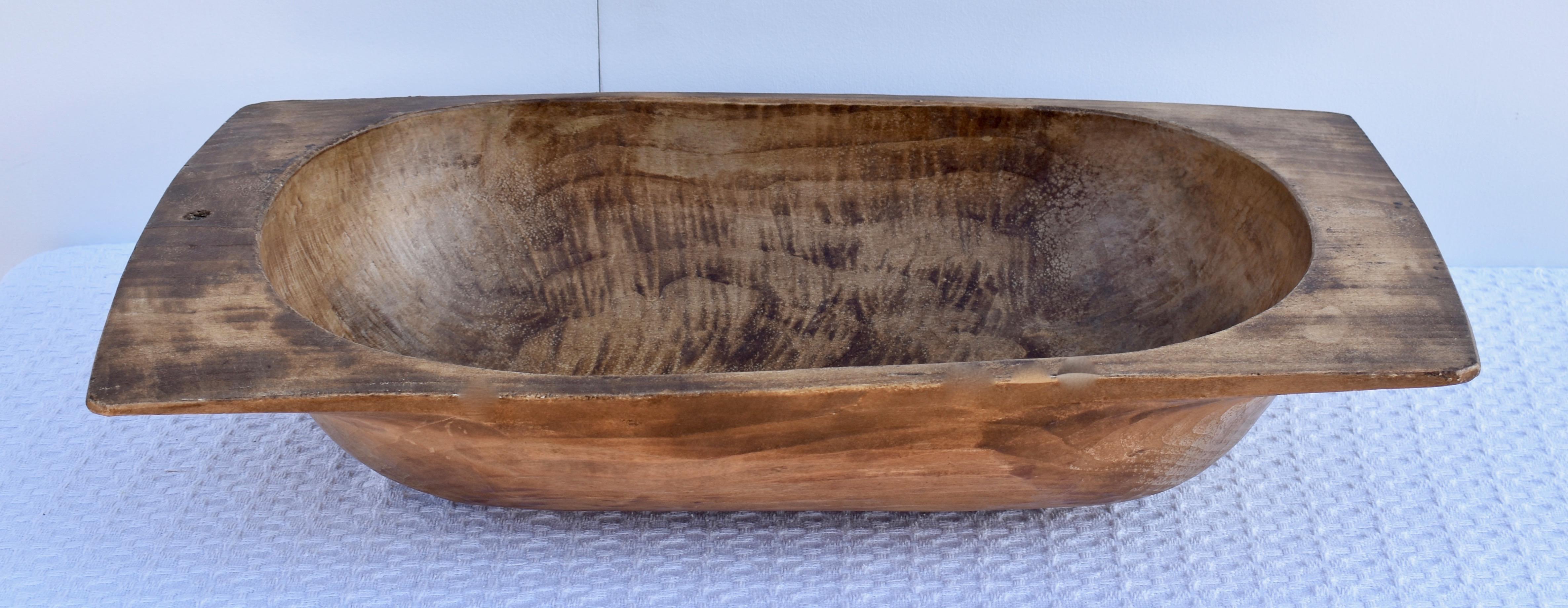 Unsere antiken europäischen Teigschüsseln aus Holz werden von Hand aus ganzen gespaltenen Stämmen gehauen. Sie zeichnen sich durch eine bemerkenswerte Handarbeit und eine schöne Patina aus, besonders wenn man sie von der Unterseite betrachtet. Sie