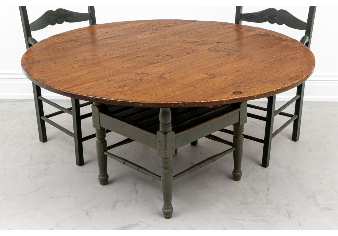 A hand hewn round table surmounted on paint decorated parts of 18th/19th century construction. The table with a lower slatted tier, turned baluster form supports and perimeter stretcher supports.
Purchased from Monique Shay in Woodbury,