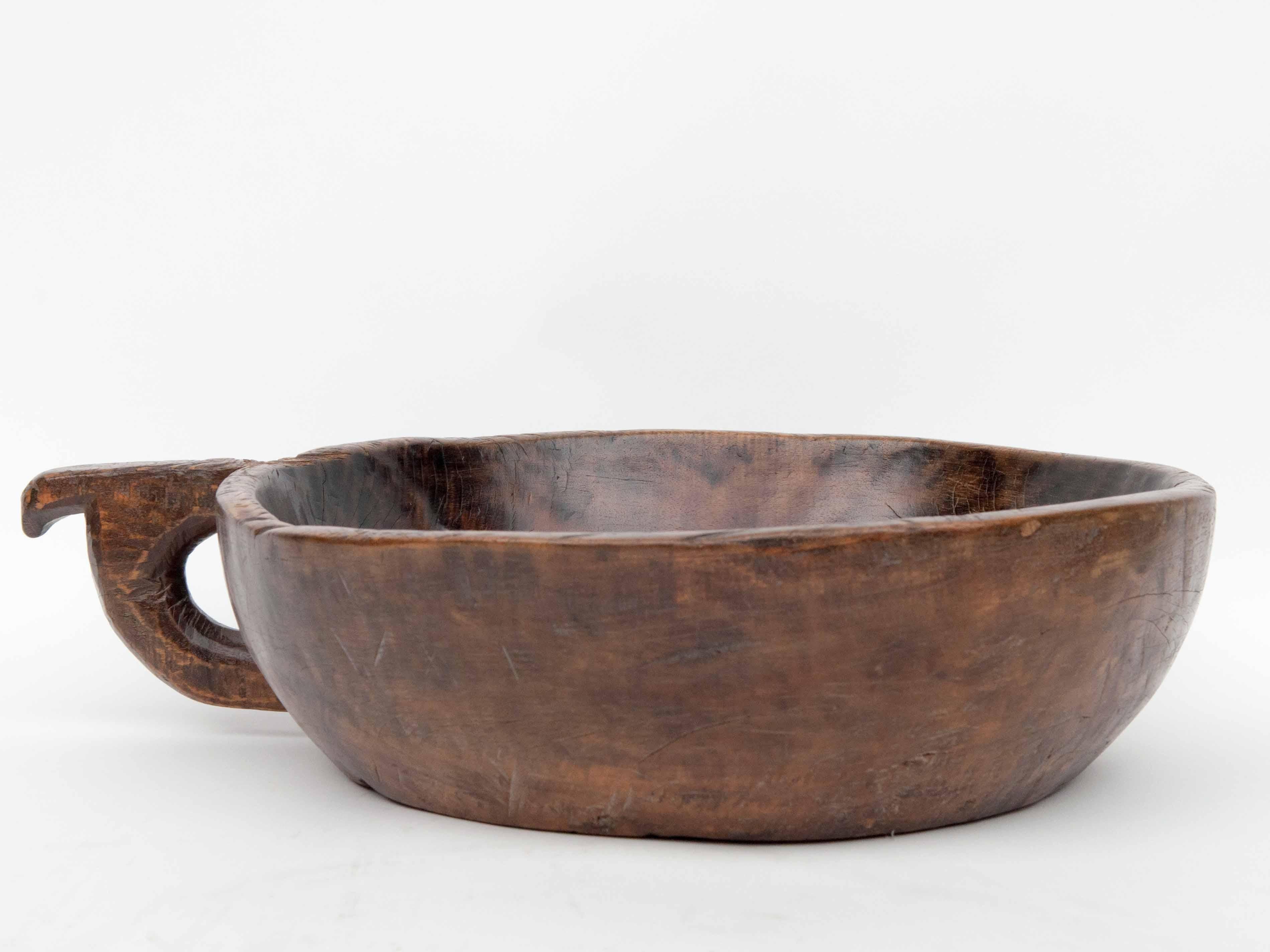 Vintage hand hewn wooden bowl with handle from the Toraja of Sulawesi, Indonesia. Mid-late 20th century.
This lovely bowl from the mountains of Sulawesi, has been fashioned by hand from a single piece of wood, and is imbued with a dark spotted