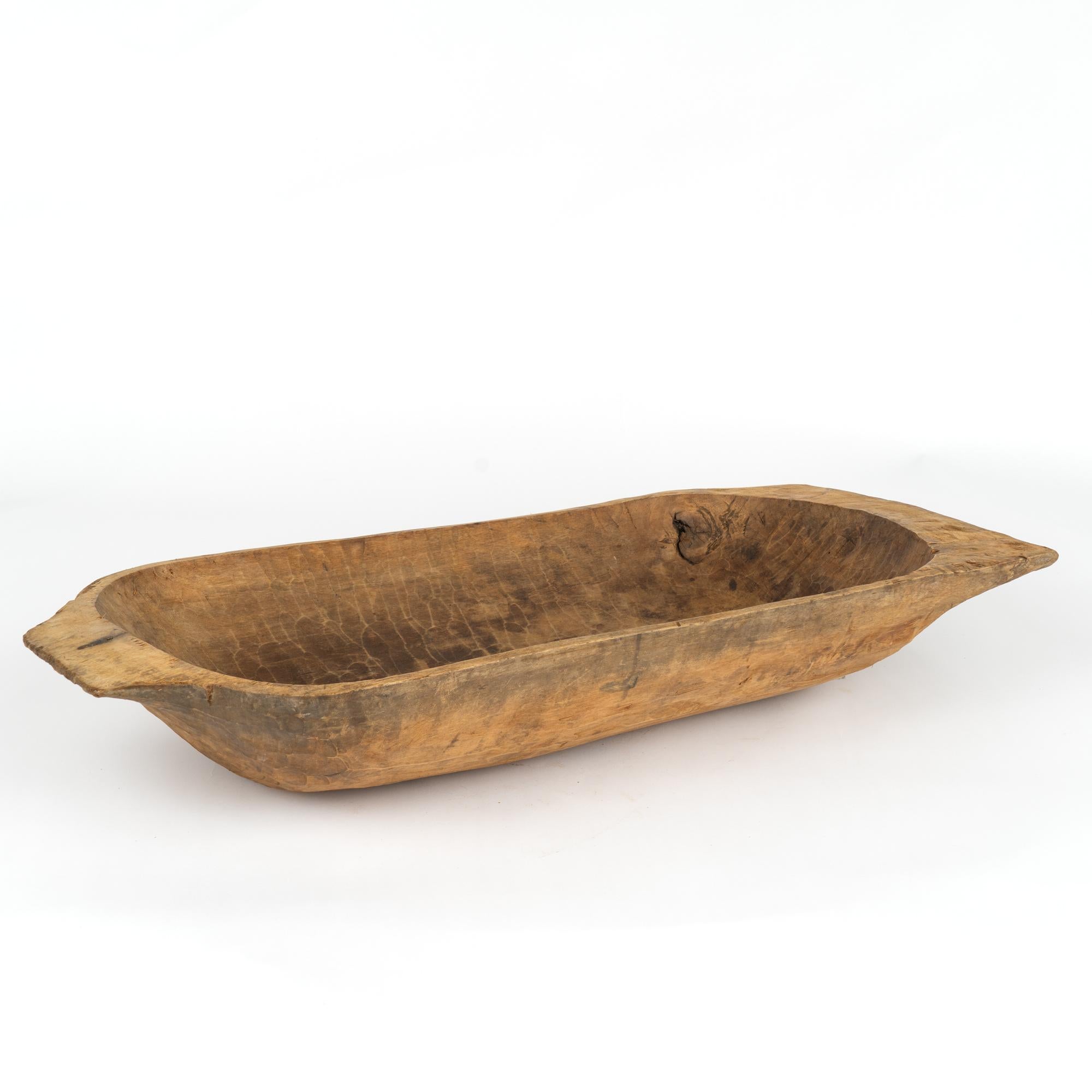 Antique hand hewn, European country dough bowl / trencher featuring a rounded rectangular shape, tapered base and handles.
Old cracks, nicks, stains, distress are reflective of generations of use. 
Waxed and ready to use as decorative bowl.

With