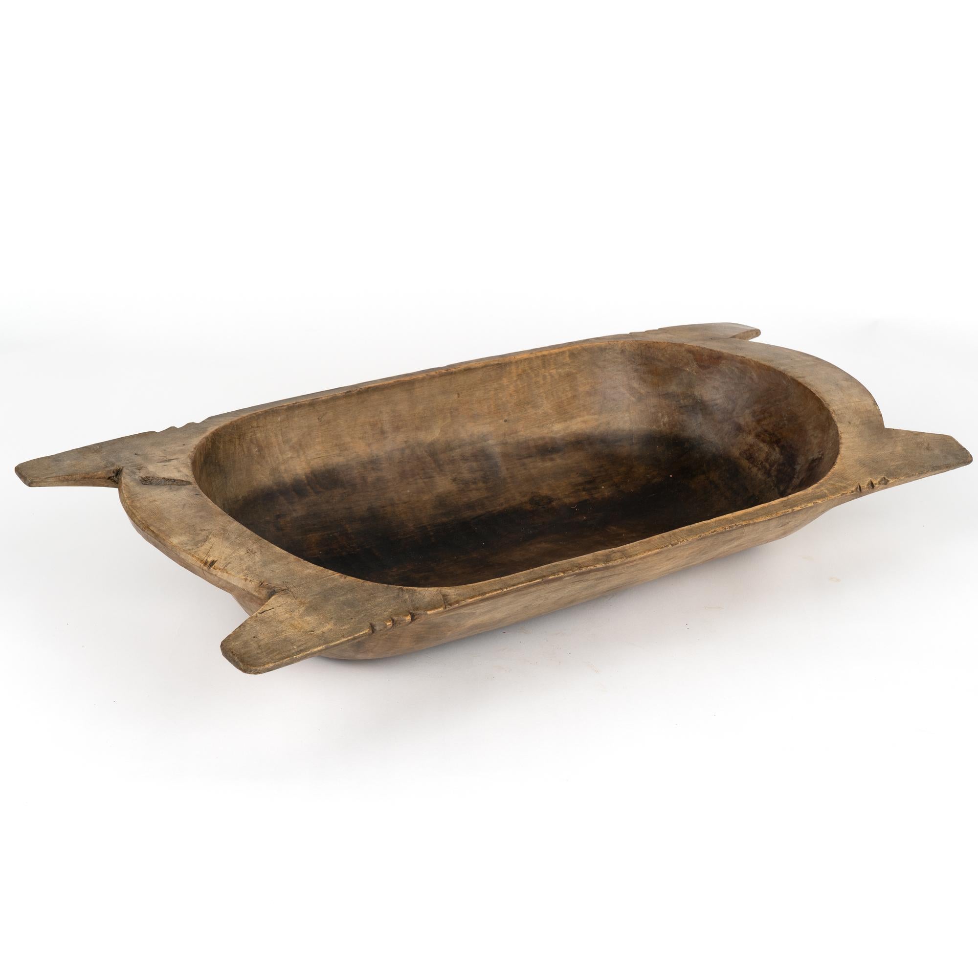 Antique, hand hewn, European country dough bowl / trencher featuring a rounded rectangular shape, tapered base and handles.
Old cracks, nicks, stains, distress are reflective of generations of use. 
Waxed and ready to use as decorative bowl.

With