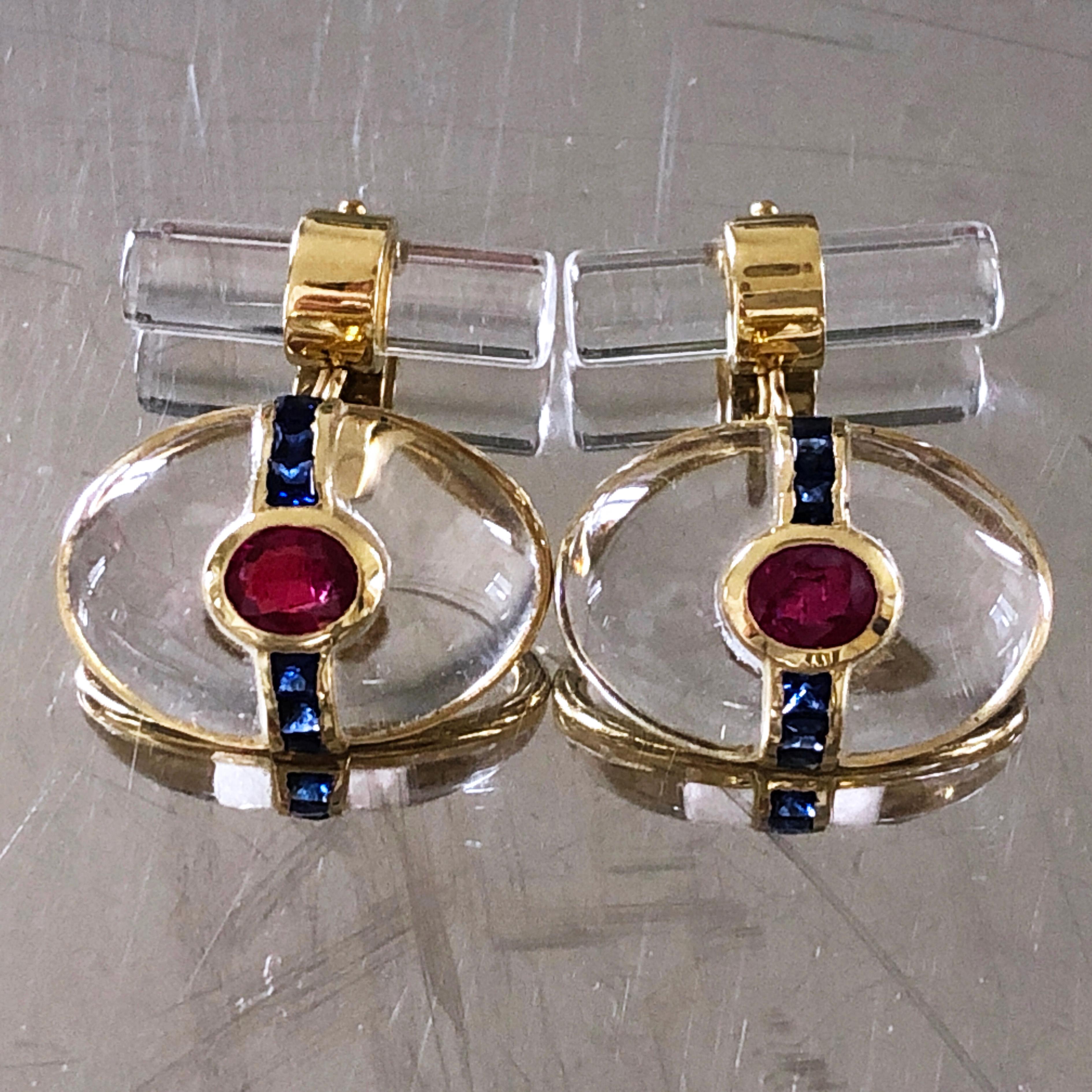 One-of-a-kind absolutely Chic yet Timeless pair of Cufflinks featuring an Oval Hand Inlaid Rock Crystal Cabochon embracing a Natural Oval Ruby and an almost 1 Carat Blue Sapphire Calibré Cut Line in an 18K yellow Gold Setting. 
A Rock Crystal Stick
