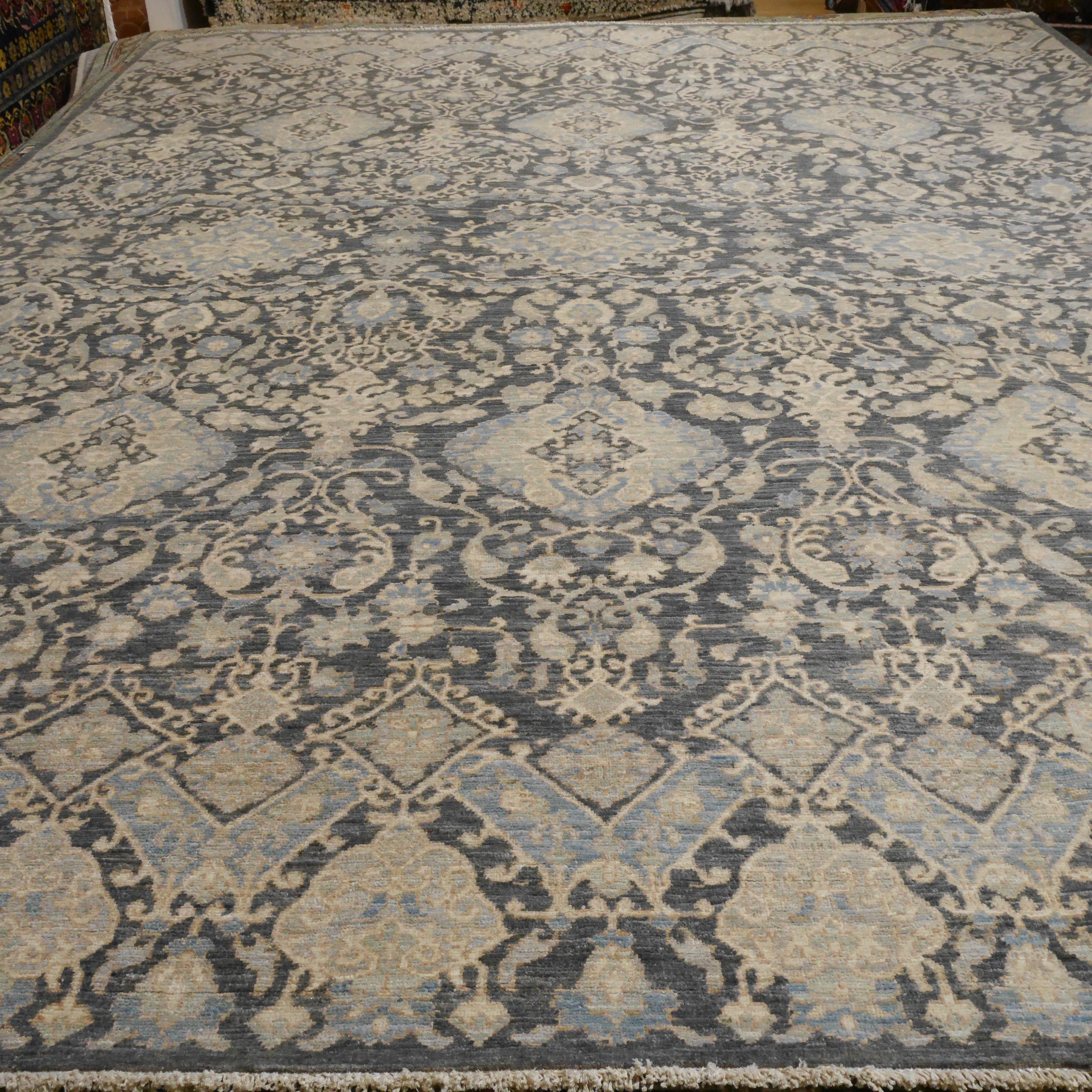 A large room sized rug with design in style of Agra.
This beautiful rug was hand knotted to fit 21st century interior needs. The background is in an elegant gray color with oriental designs.
Agra design rugs are very looked after since they go