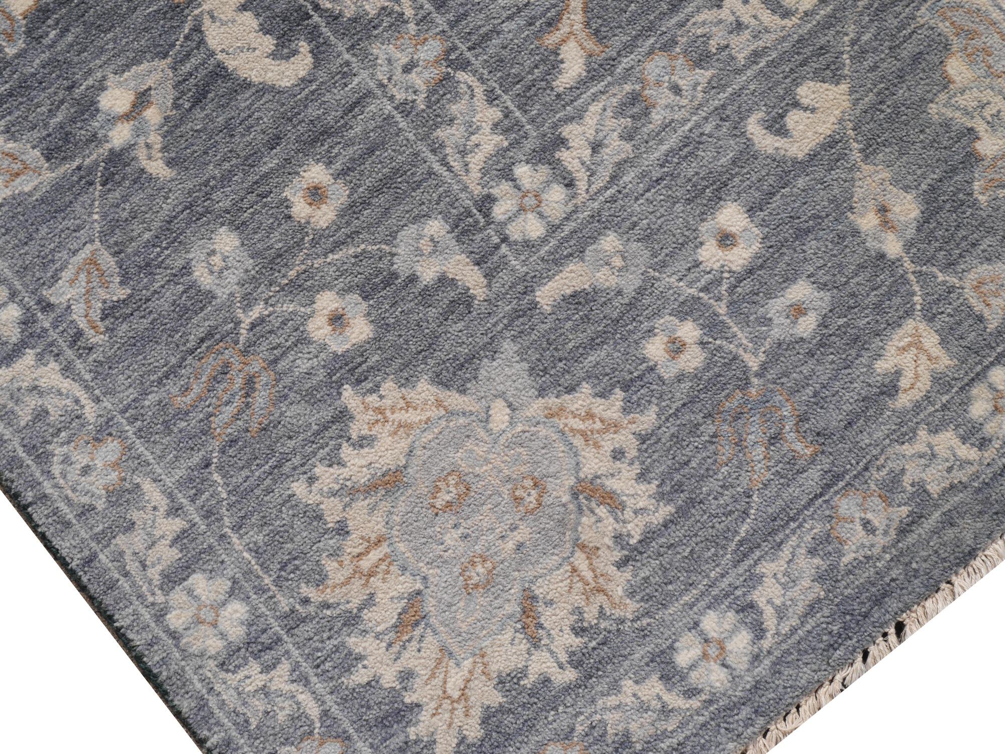 A large room sized rug with design in style of Oushak.
This beautiful rug was hand knotted to fit 21st century interior needs. The background is in an elegant gray color with floral designs.
Oushak design rugs are very looked after since they go