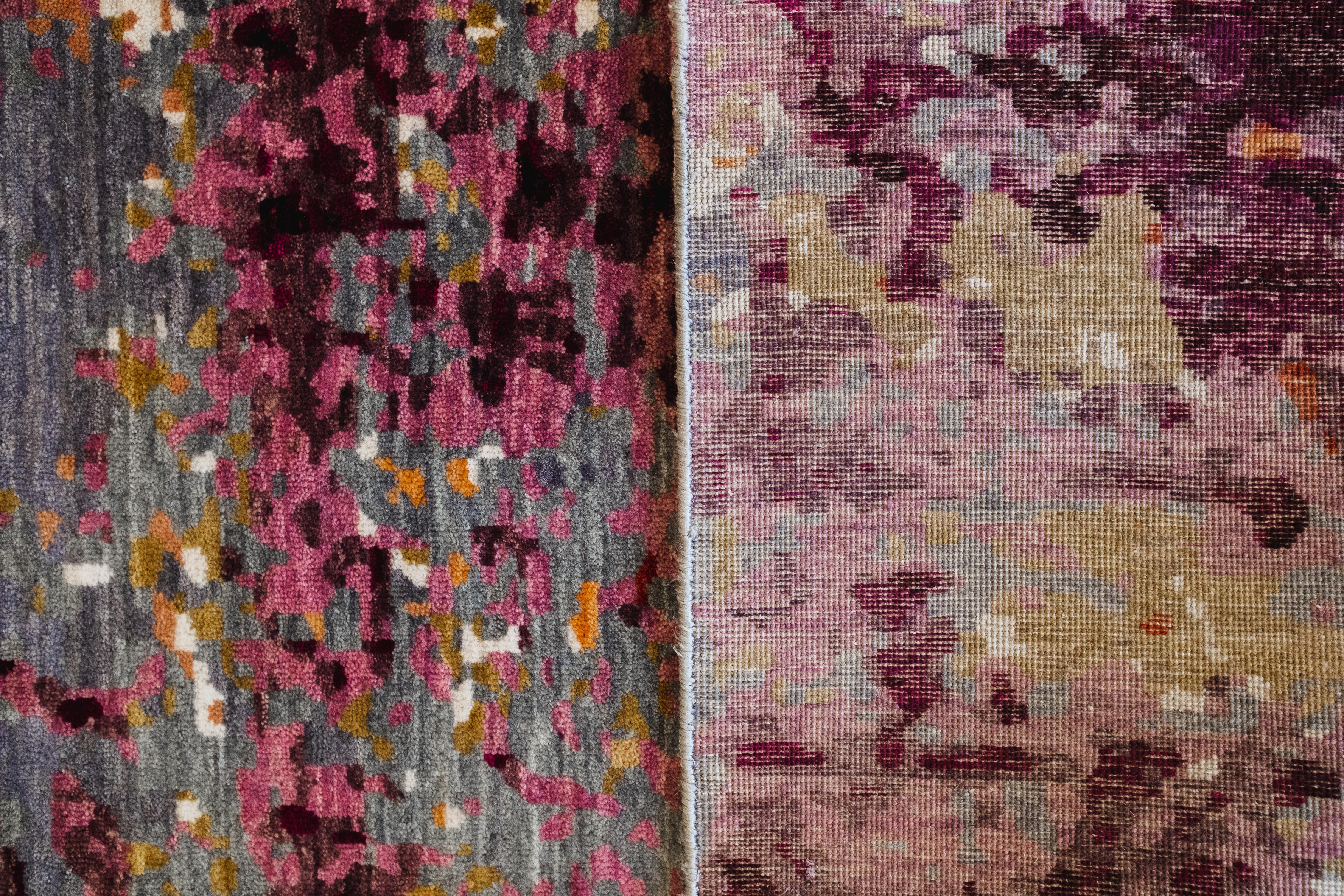 Questo tappeto persiano astratto in lana annodato a mano nei colori blu, viola, rosso e giallo, che misura 8' x 10', offre una fusione ipnotica di colori e movimento. Ispirato dal gioco di luce e texture, il design evoca l'essenza di un dipinto