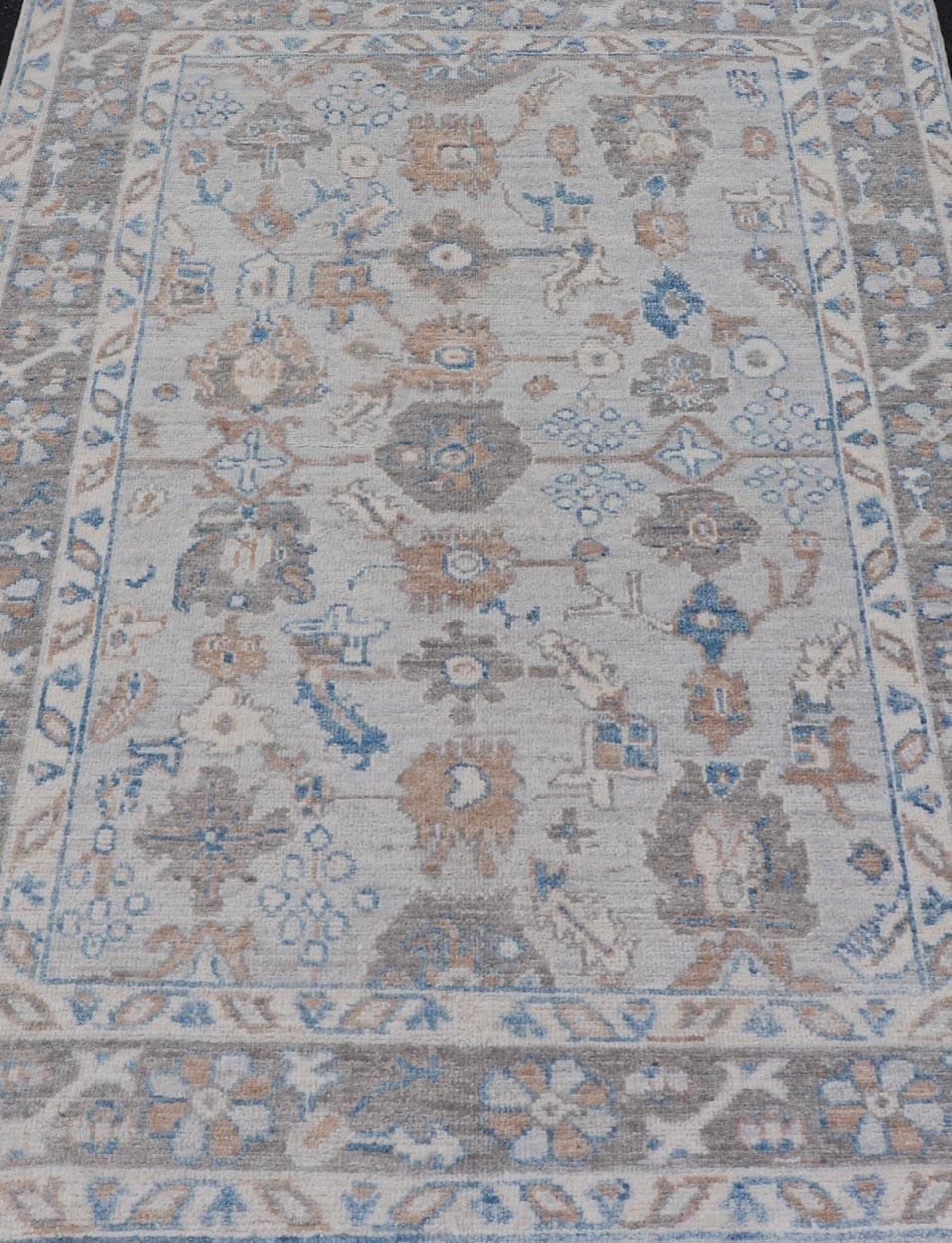 This beautiful Oushak piece starts with a floral border. The field has a modest light blue background with an all-over design rendered with earthy tones, such as wood brown, tawny brown, tans, ivory and hints of blue.  

Measures; 4'1  x 6'3