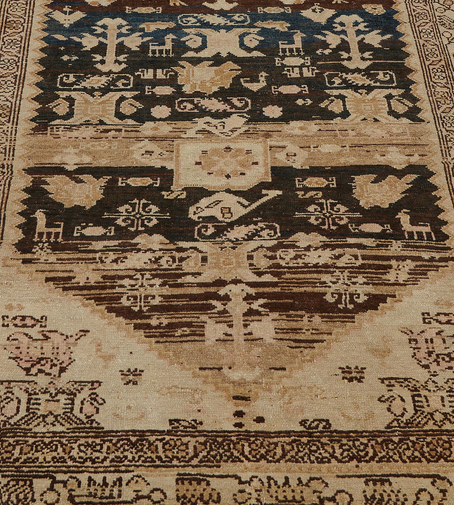 This antique, circa 1900, Persian Malayer runner has a shaded charcoal-blue and brown abrash field with a central terracotta-pink stepped medallion with angular flowerhead pendants containing a central square lozenge and surrounded by delicate