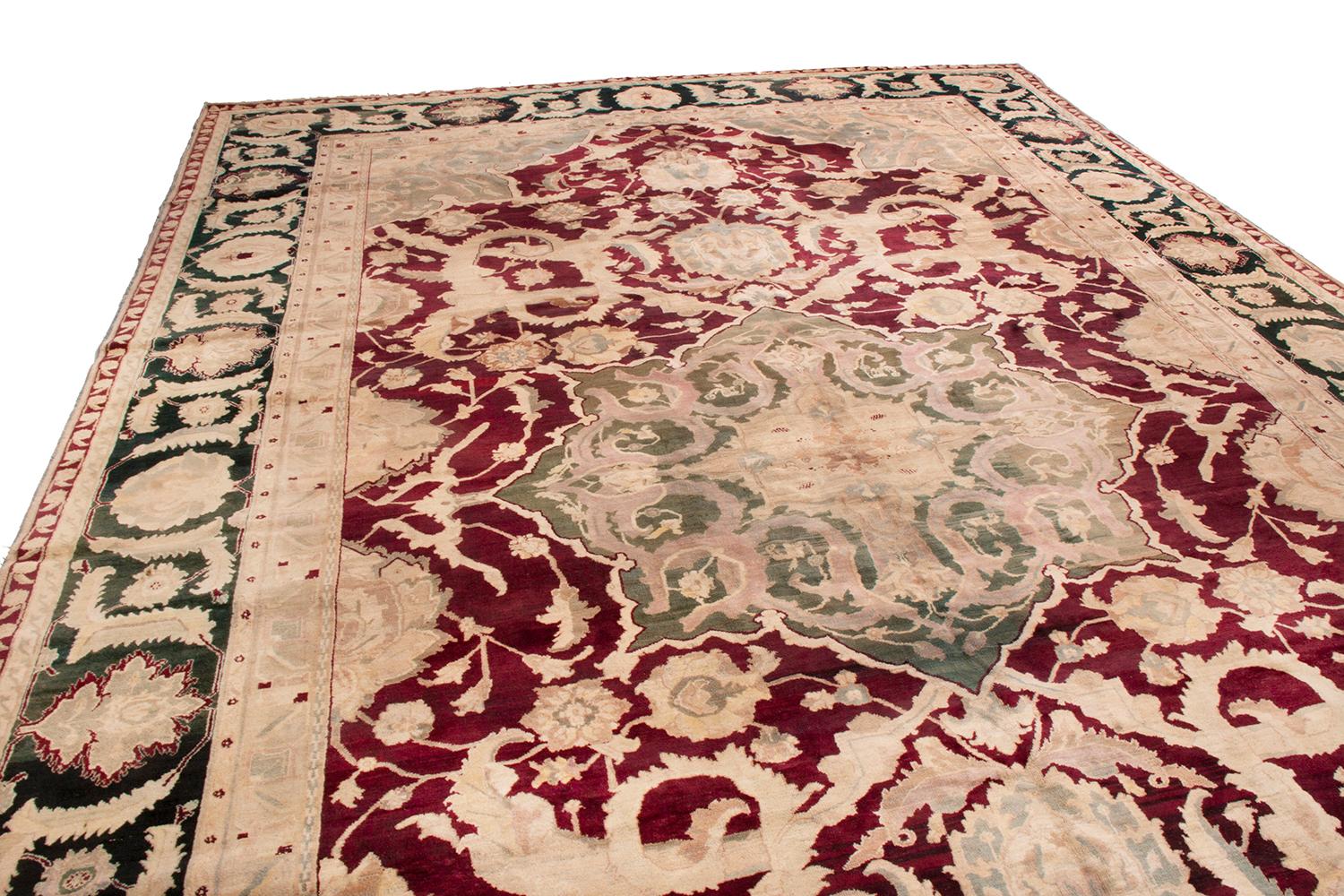 Hand knotted in wool originating from India, circa 1890-1900, this regal 10 x 17 antique rug connotes a unique traditional Agra rug design, borrowing rich influences from classic Polonaise rugs of the 17th century in its take on a venerated