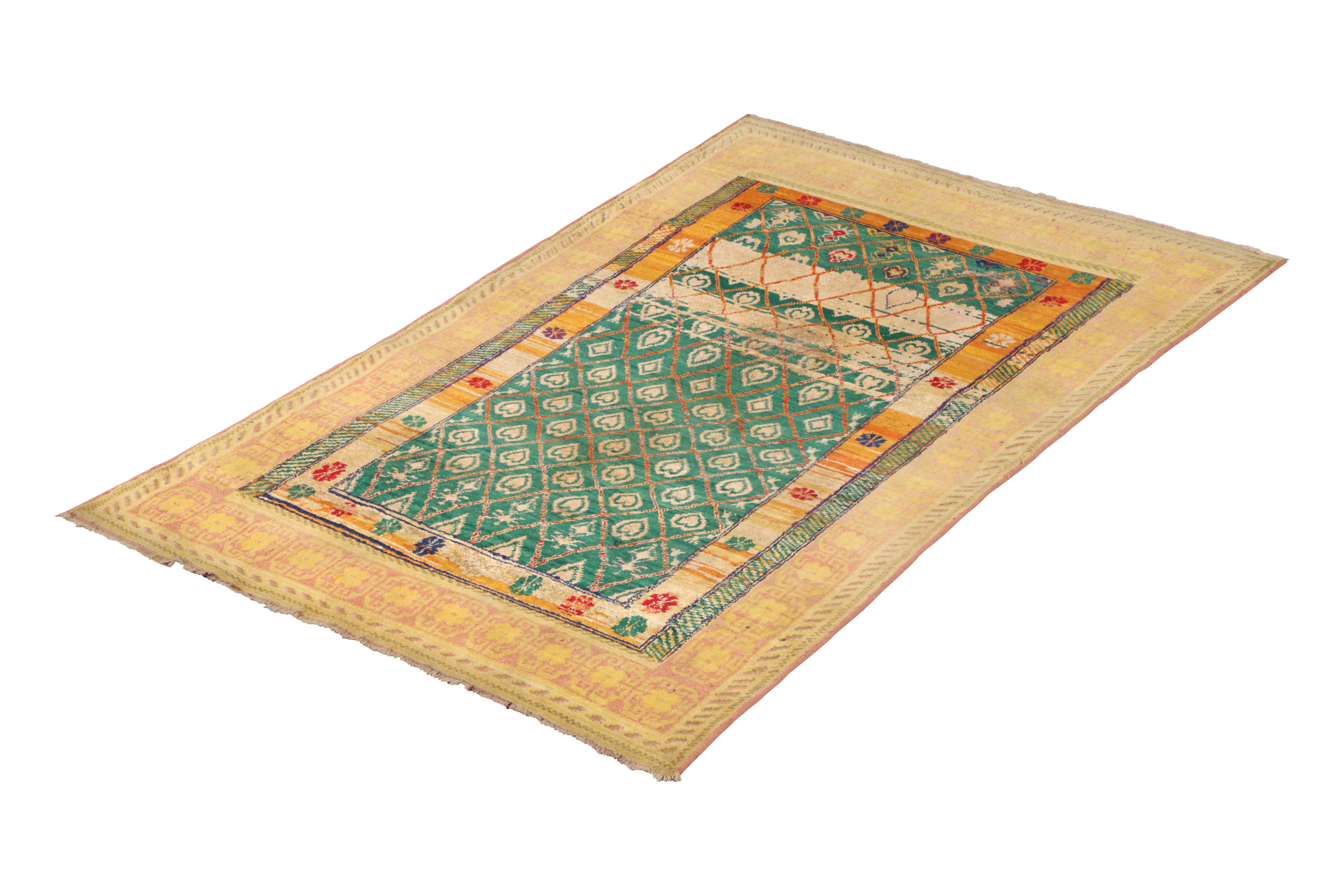 Hand knotted in a fabulous cotton and silk blend originating from India circa 1910-1920, this antique rug connotes a rare Agra rug design favoring unique green and yellow colorways in a geometric tribal pattern. The silk’s natural luster brings out