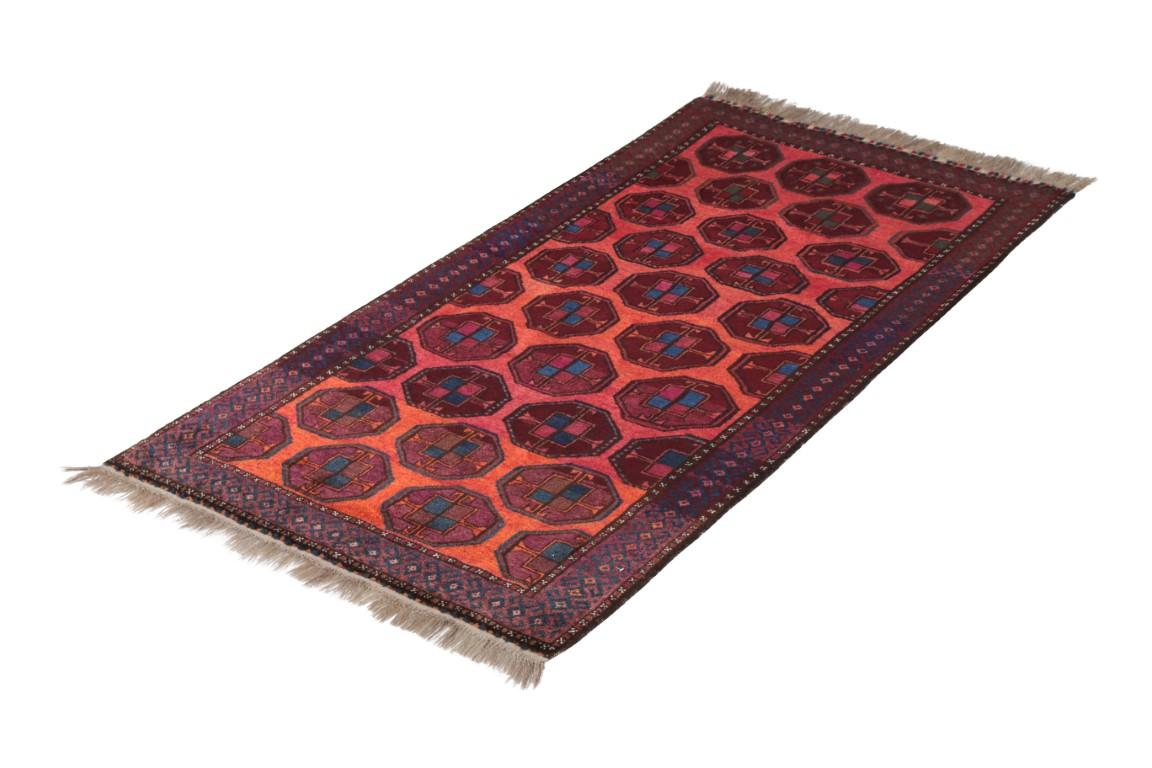 Dieser antike Perserteppich aus handgeknüpfter Wolle aus der Zeit um 1920-1930 ist ein Übergangsdesign der Belutschen mit außergewöhnlichen, unverwechselbaren Farben, die Rottöne mit blauen Akzenten in einem geometrischen 4x5-Muster verbinden, das