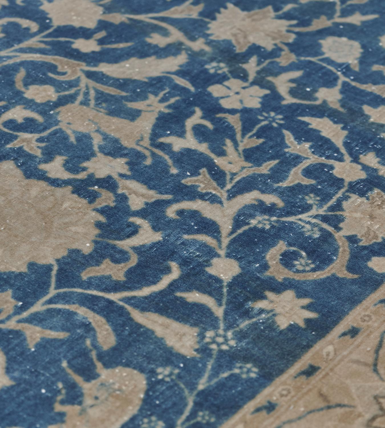 Dieser antike Agra-Teppich um 1900 hat ein schattiertes, himmelblaues Feld mit einer zentralen, gehöckerten, buff-braunen Palmette, aus der eine zarte Blumen- und Palmettenranke mit gepaarten Tieren hervorgeht, in einer buff-braunen Bordüre aus