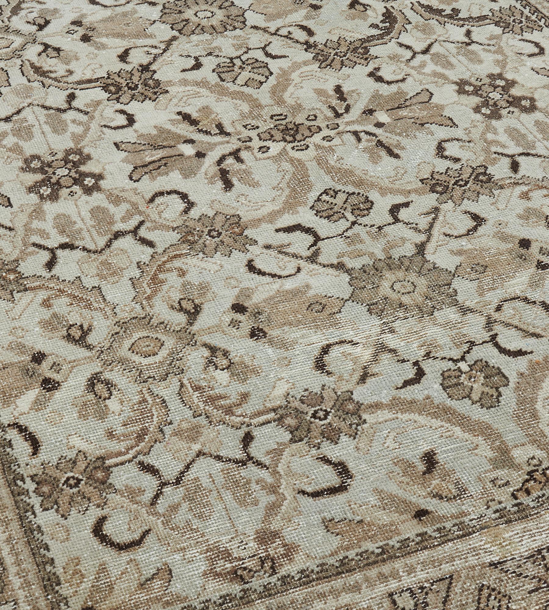 Esta alfombra antigua de Sultanabad, de hacia 1920, presenta un campo de agua de nilo con un diseño general de palmetas de color marrón topo, marfil y marrón suave, enlazadas por una enredadera de flores y grandes hojas dentadas, en un borde marrón