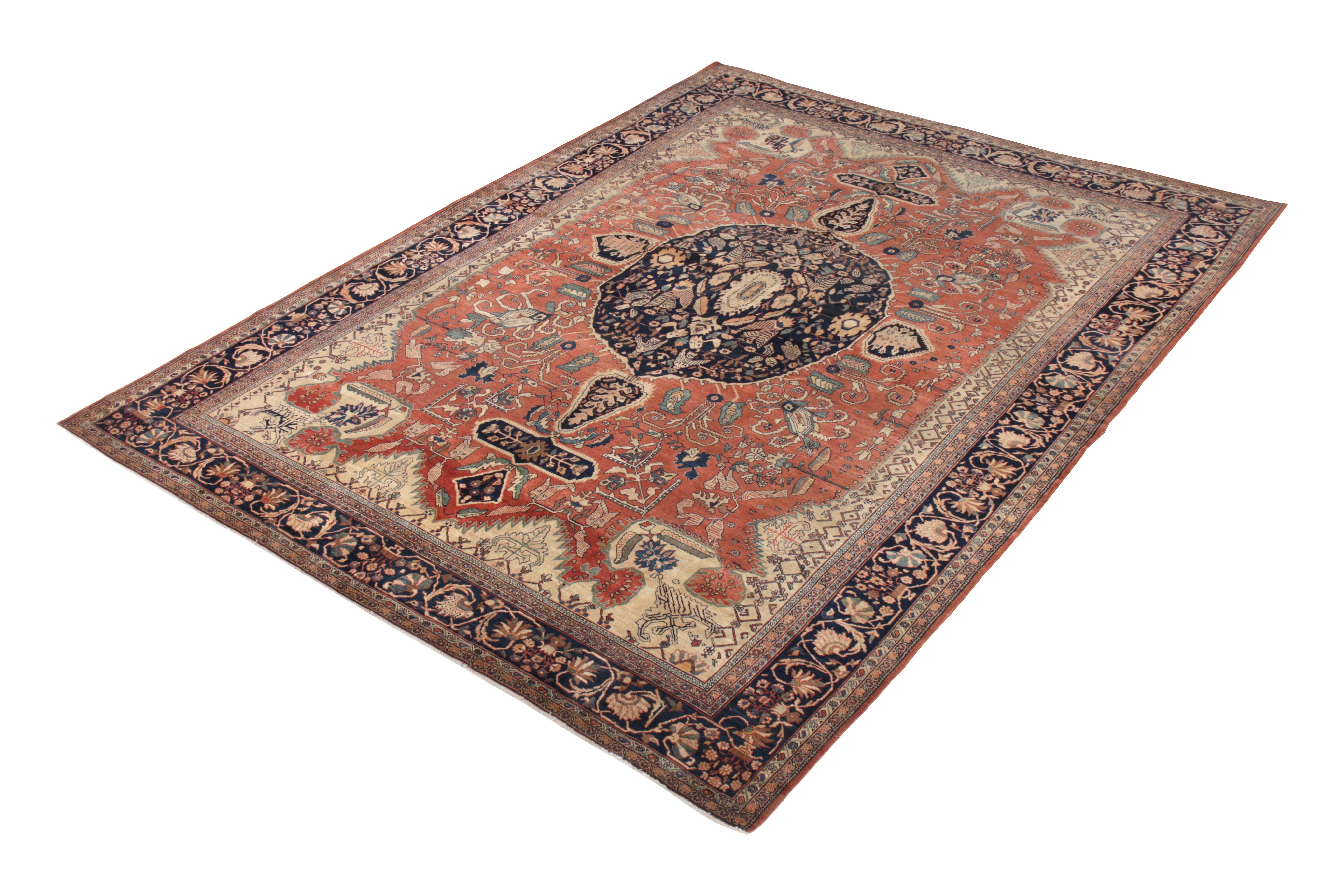 Hand knotted in wool originating circa 1900-1910, this 10 x 12 antique rug connotes a Farahan rug design of particular grandeur, depicting a regal medallion pattern in the deep blue colorway background accenting the prevailing, handsome red and