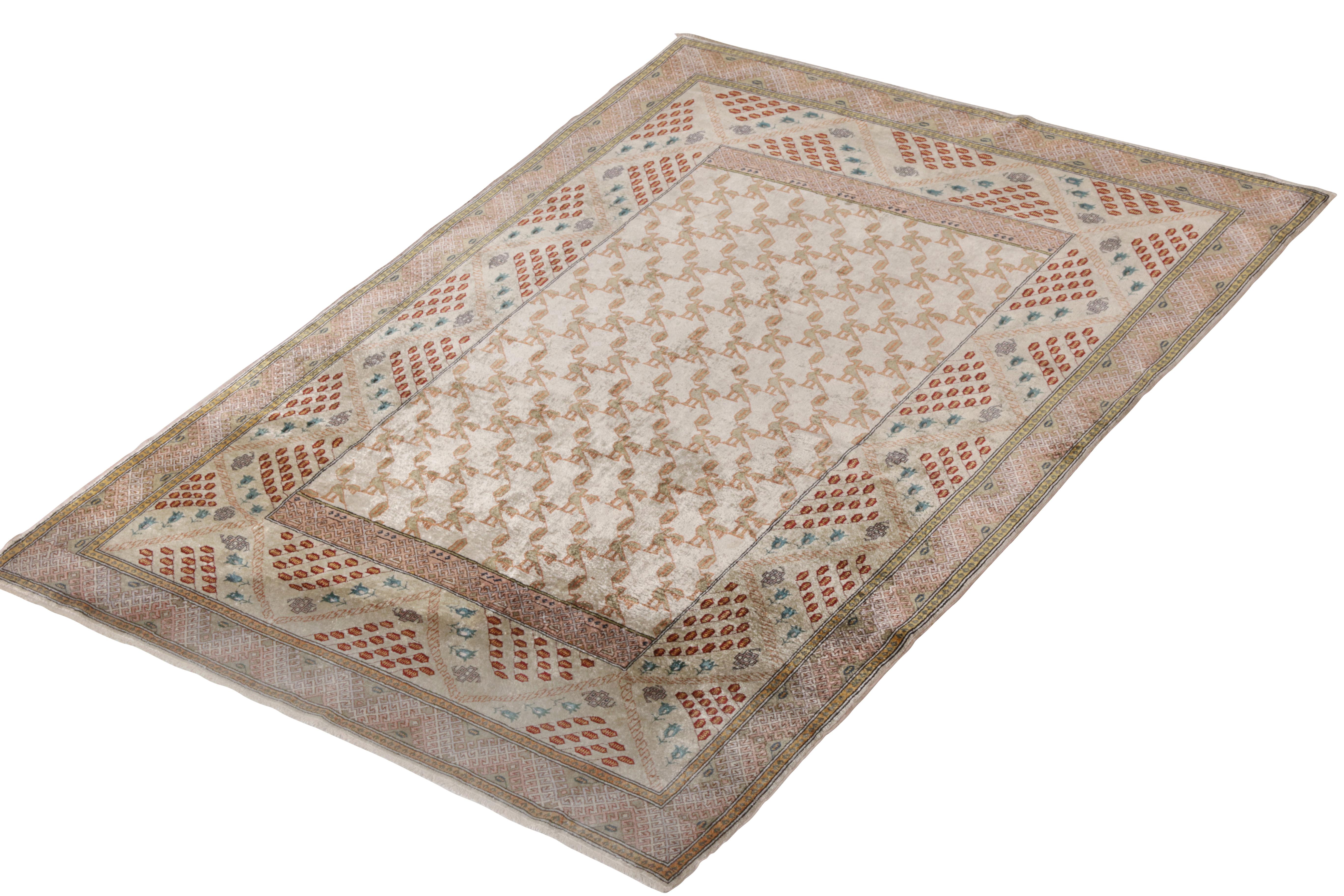 A spectacular antique 4x6 Hereke rug of hand-knotted silk and metal yarns, originating from Turkey circa 1910-1920. Enjoying a subtle pink accent atop beige-brown colorways, complementing a unique series of geometric and pictorial allusions.