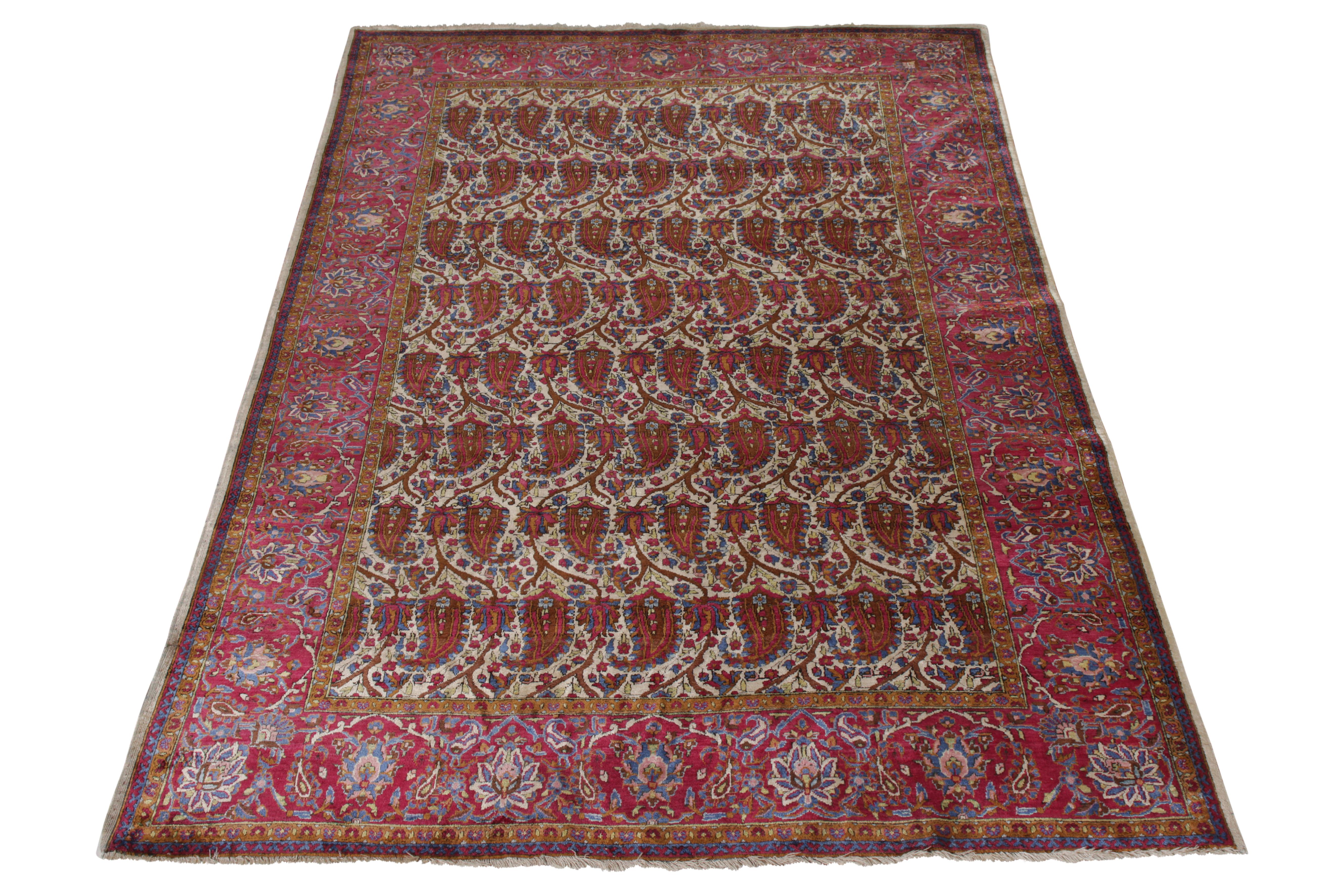 A 4x7 antique Persian rug of renowned Kashani origin, honoring classic paisley patterns in prevalent red and beige-brown hues. Hand knotted in wool circa 1910-1920, an antique Kashan rug both celebrating traditional designs and exemplifying its