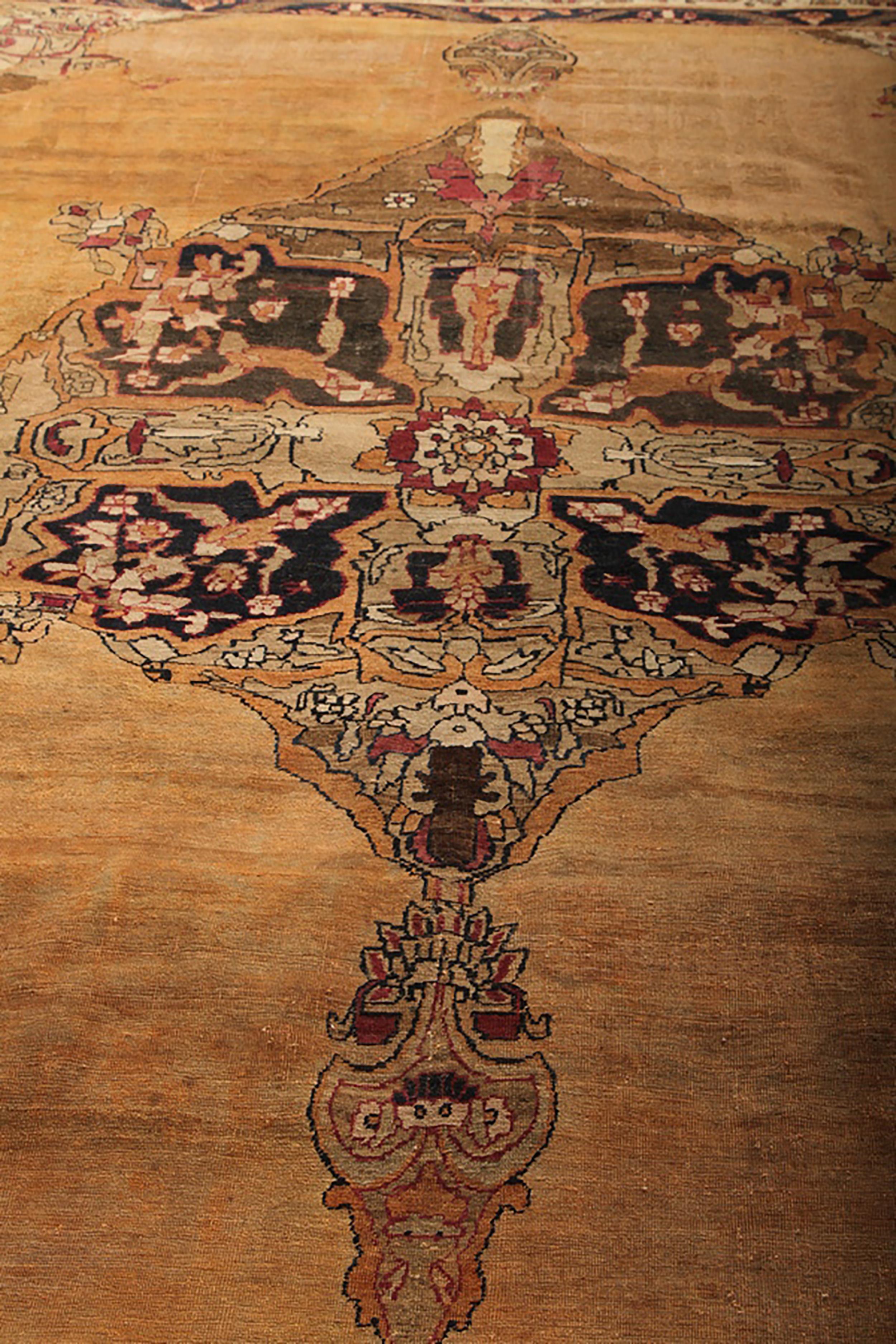 Hand knotted in wool originating circa 1890-1900, this antique Persian rug connotes the celebrated Kerman rug style, named for the titular region of renown for its pieces in regal scale and intricacy like this take on the venerated medallion style.