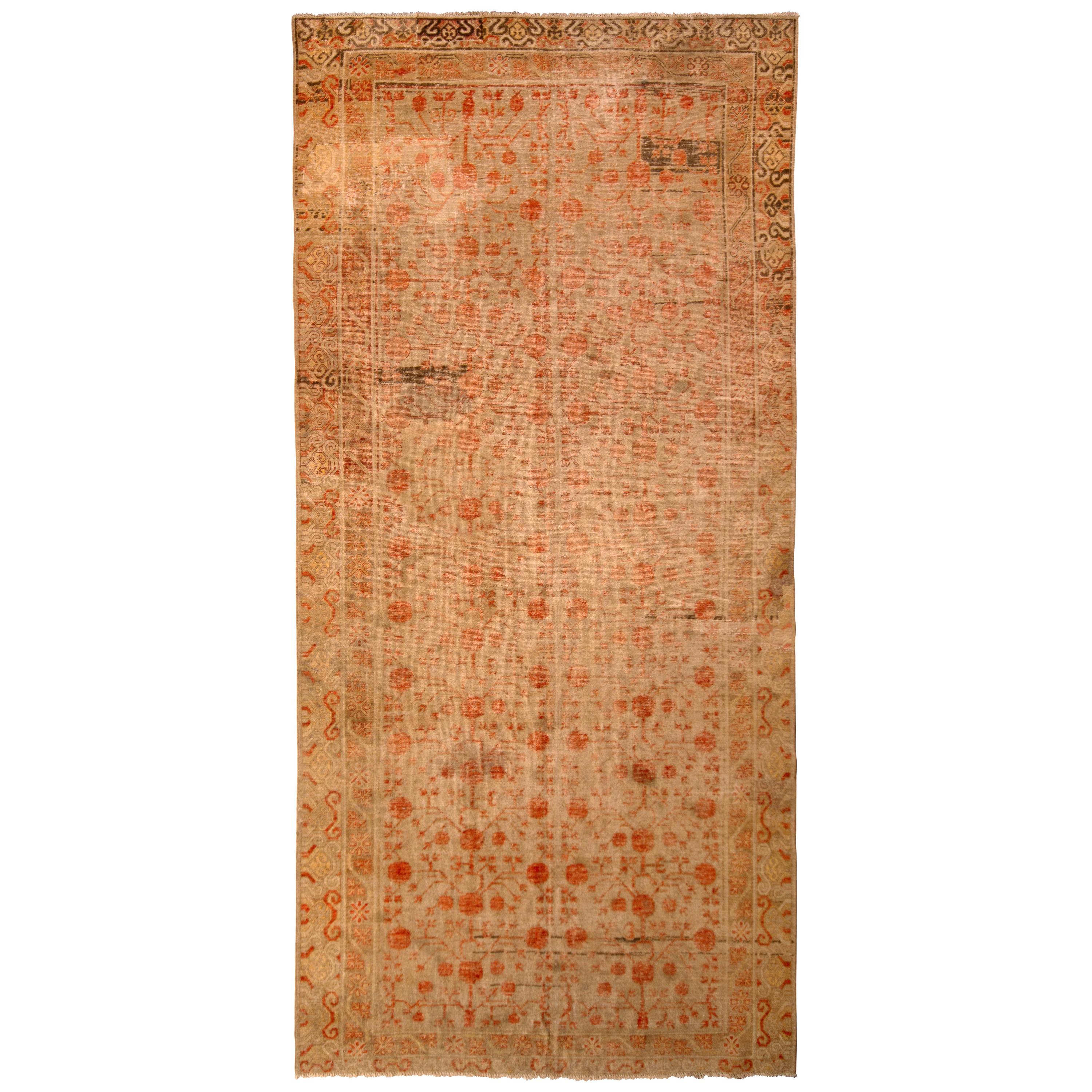 Hand knotted in wool originating from East Turkestan circa 1890-1900, this antique rug is one of the most spacious we’ve seen from the Khotan rug design family, nearly gallery sized in 6’5 x 13’5 with a notable, charming look of wear in the upper
