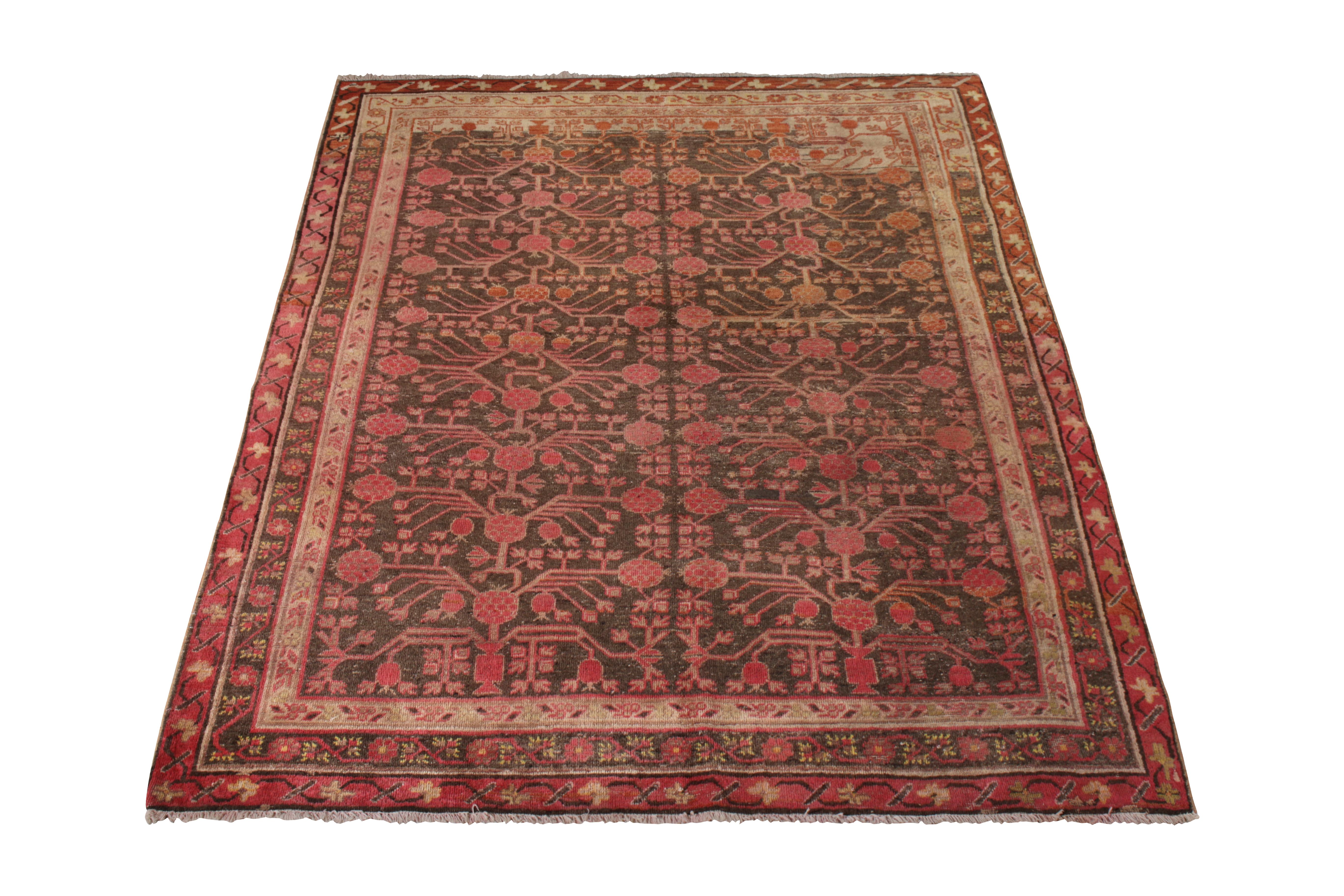 An antique 5 x 8 Khotan rug in rich red and brown, hand-knotted in wool circa 1910-1920 from East Turkestan. Celebrating the classic pomegranate pattern this particular oriental rug lineage favors in inviting repetition and detail. Further enjoying