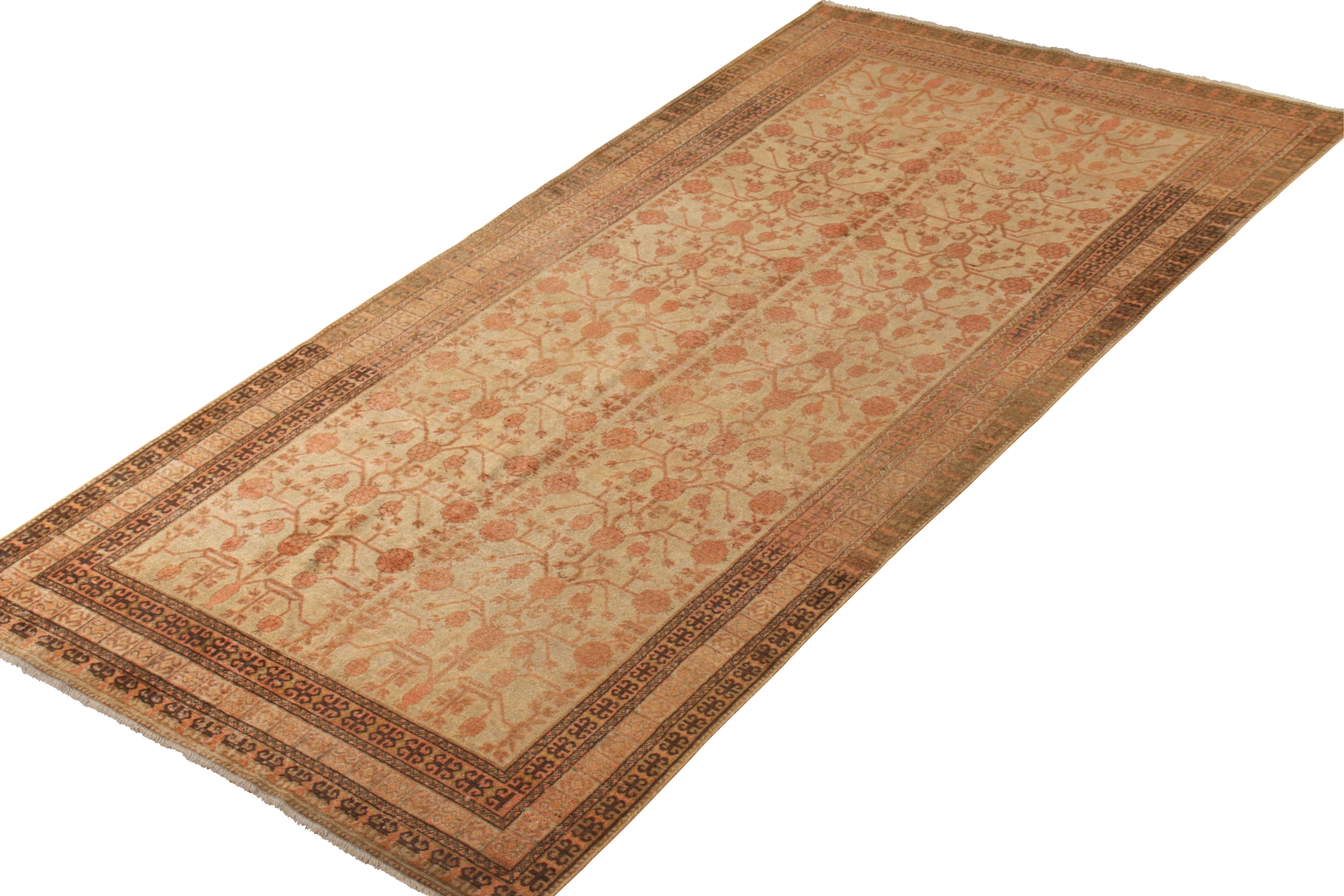 An antique 6 x 12 Khotan rug of a rare green background, playing with red and beige-brown in classic pomegranate patterns. A traditional design and celebrated pattern, hand knotted in a low-pile wool, originating from East Turkestan, circa