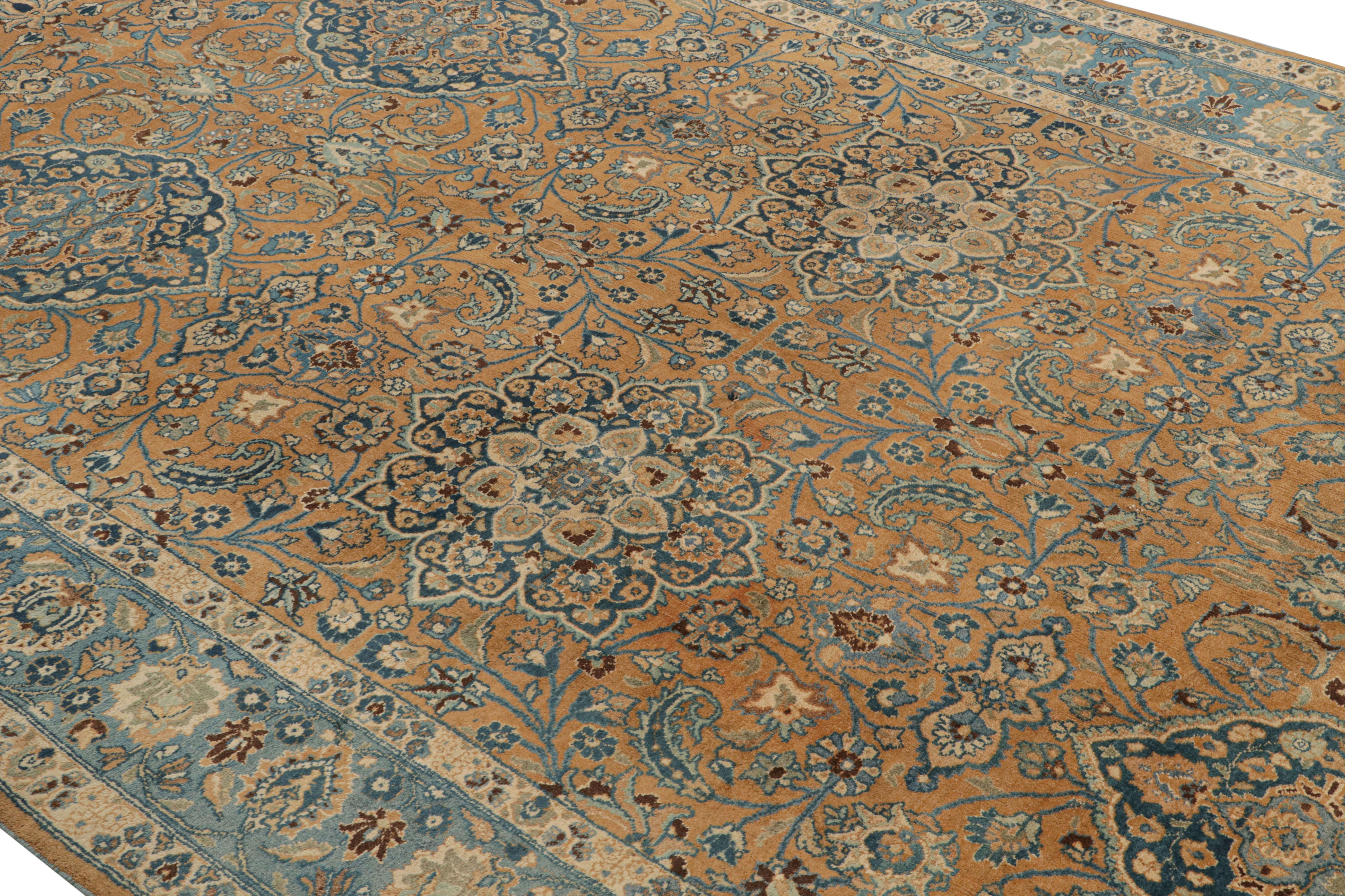 Hand knotted in wool originating circa 1910-1920, this 7 x 12 antique rug connotes a traditional Mashad rug style of exceptional drawing and rich color, marrying a luxurious all-over floral pattern through a play of beige-brown and blue for a