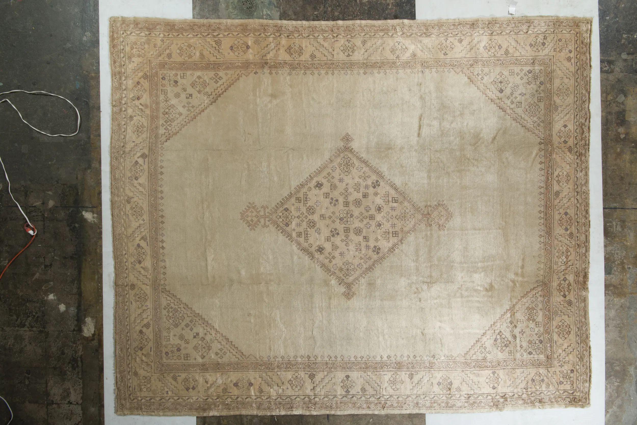 Un ancien tapis Oushak 11x13 en beige, noué à la main en laine originaire de Turquie vers 1890-1900. Ce tapis Oushak ancien particulier présente un motif en médaillon et des accents subtilement intrigants, illustrant des œuvres uniques de cette
