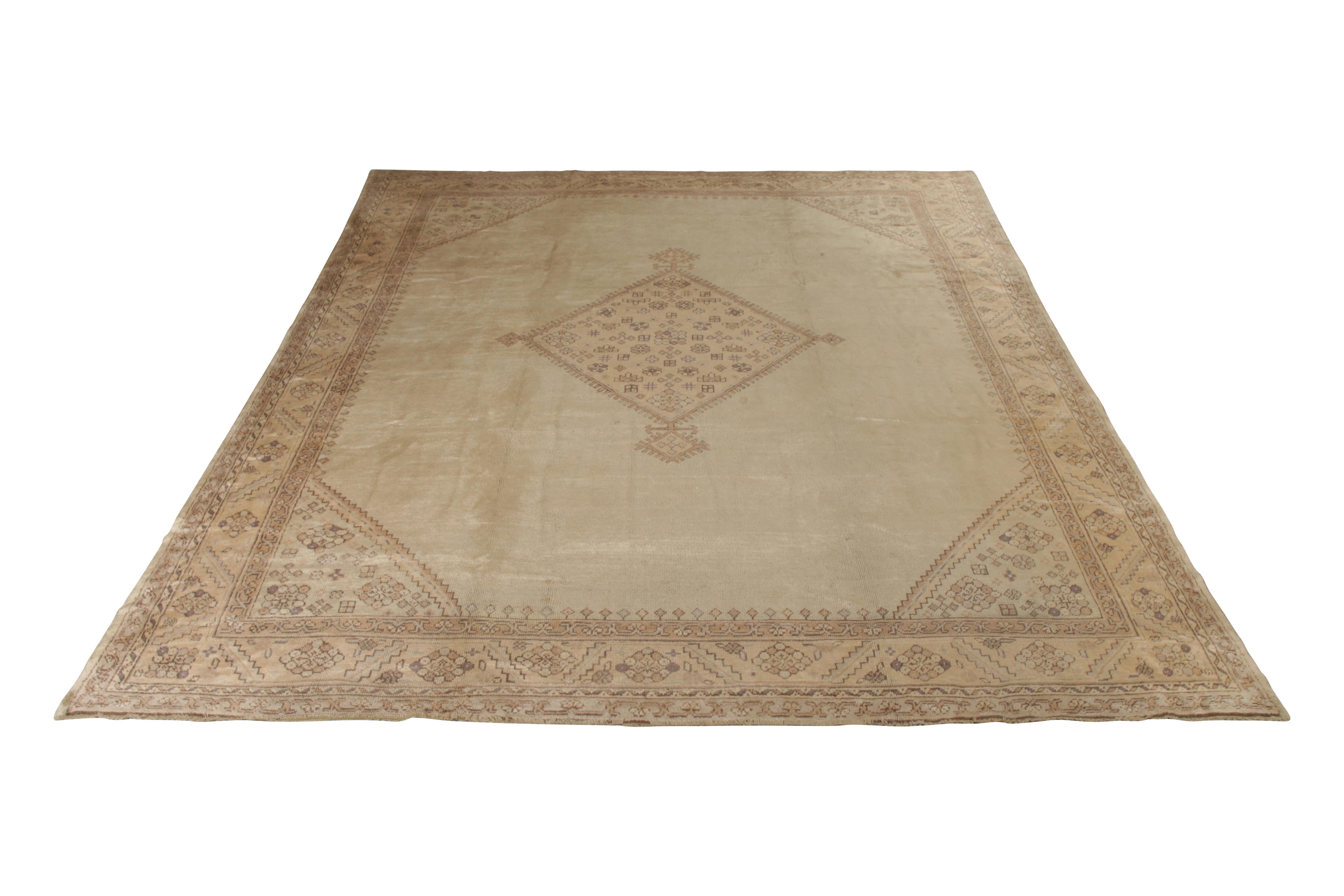 An antique 11x13 Oushak rug in beige, hand knotted in wool originating from Turkey circa 1890-1900. This particular antique Oushak rug plays a medallion pattern alongside subtly intriguing accents, exemplifying unique works of this lineage.