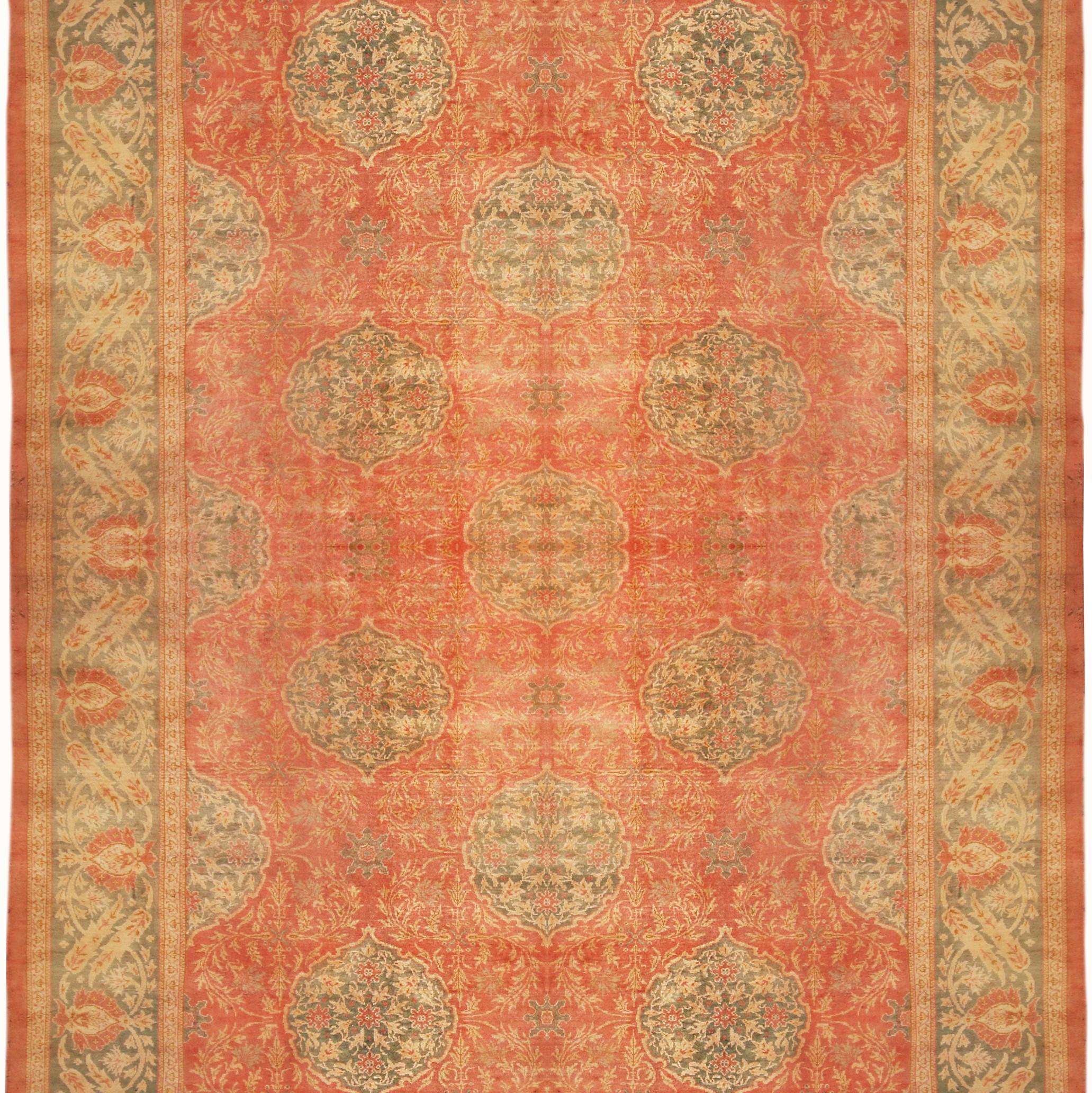 Hand knotted in wool originating from Turkey circa 1890-1900, this antique rug connotes a unique transitional Oushak rug design of particular rarity in its large size 12 x 17 dimensions and colorway alike-rich hues of red and green as the foreground