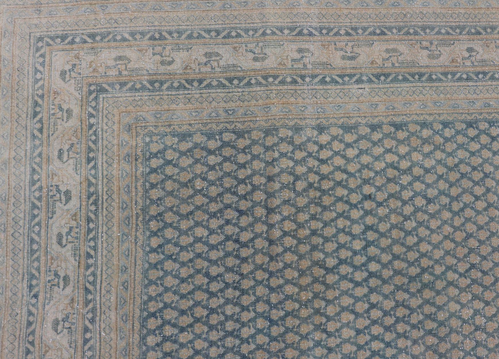Dieser Täbriz-Teppich zeichnet sich durch eine relativ komplizierte und detaillierte Bordüre und ein völlig spärliches und kleines, sich wiederholendes Stammesmotiv im Mittelfeld aus. Die Farbtöne dieses bezaubernden Teppichs verstärken die Patina