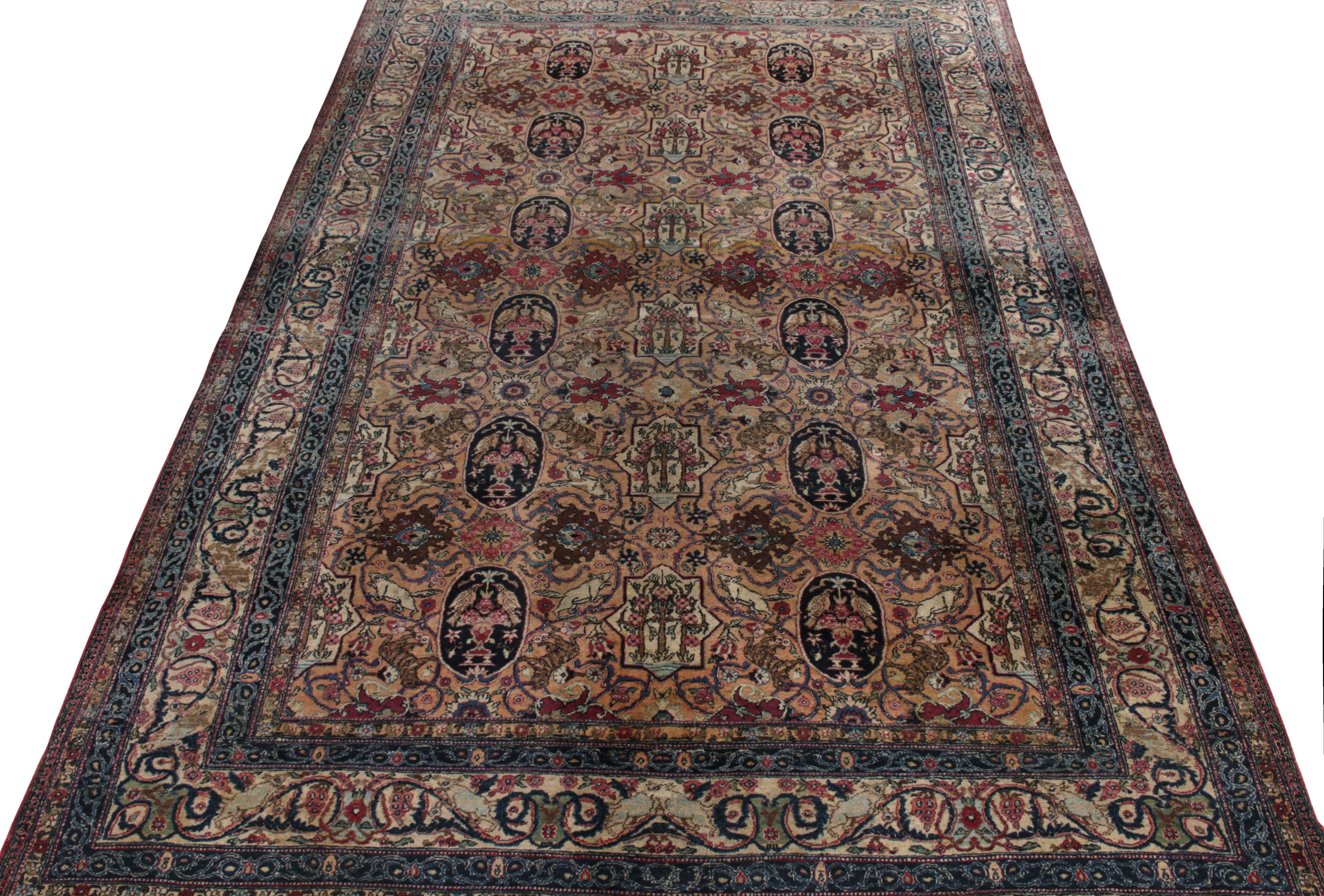 Hand-knotted in wool, a 7x11 antique Persian rug from Tehran showcasing fine craftsmanship of the 1920s with royal blue, beige & wine colored florals juxtaposed by tones of gold, olive green and sky blue on field & border alike—further nestling
