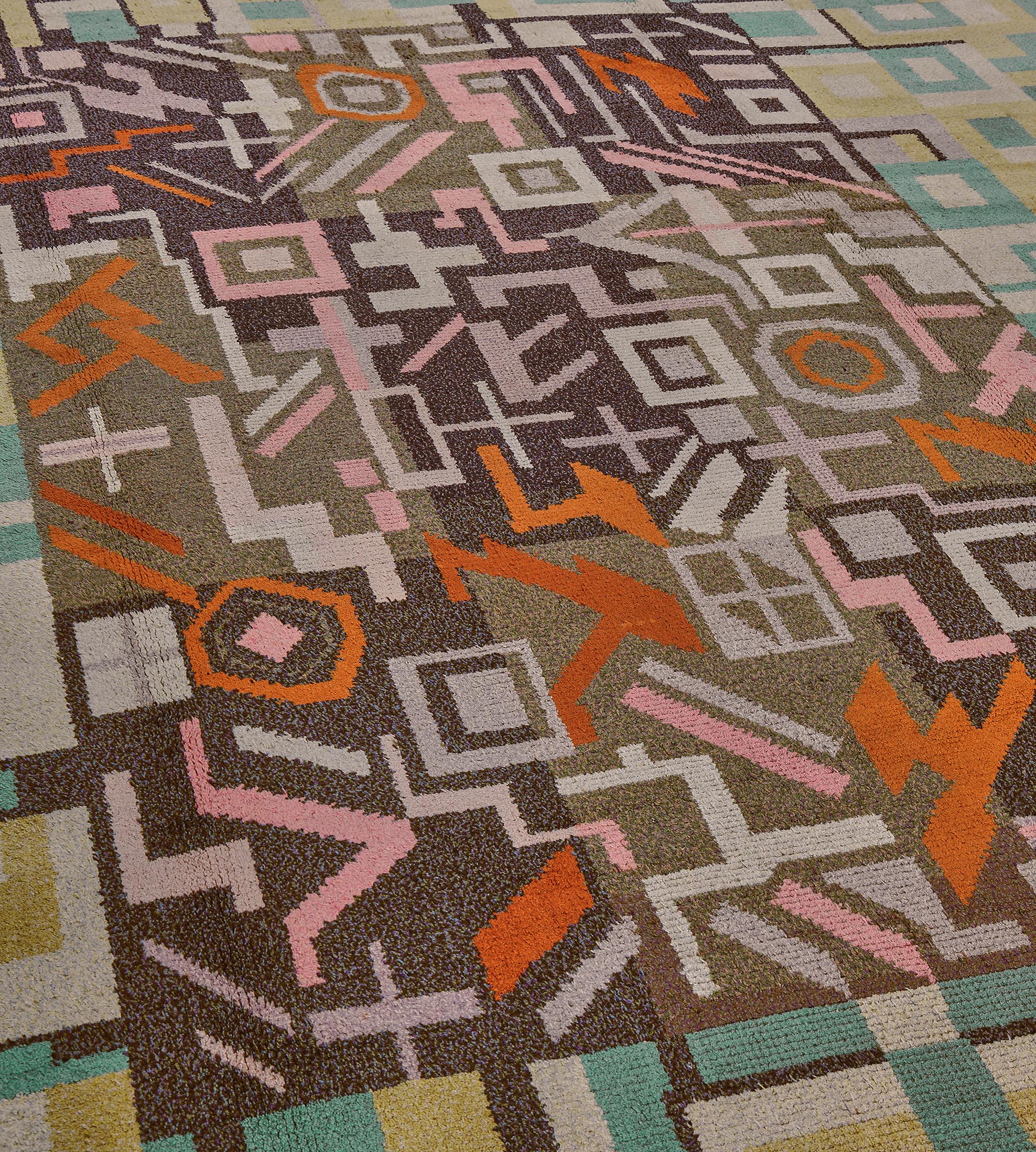 Ce tapis suédois traditionnel tissé à la main présente un champ en damier beige et anthracite recouvert d'un motif géométrique inattendu, dans une magnifique bordure déco turquoise, une sous-bordure géométrique extérieure gris ivoire.