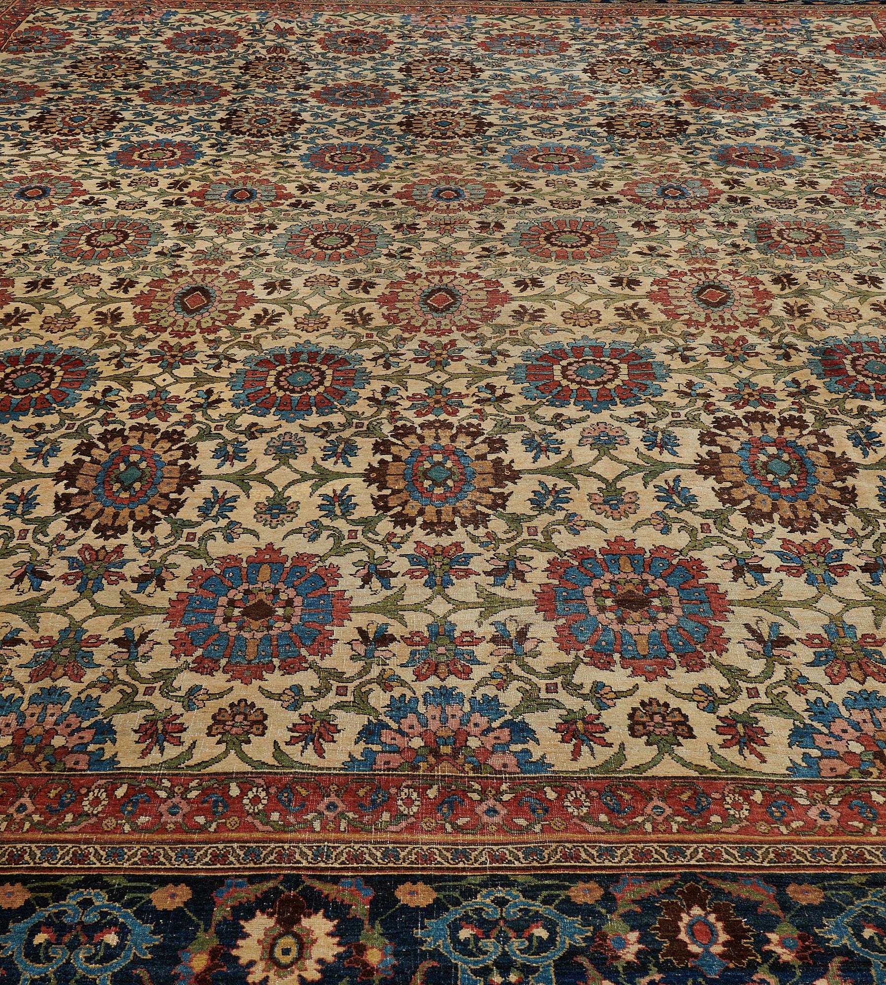 his antique, circa 1880, Bidjar rug has an ivory field with an overall design of diagonal rows of polychrome bold lozenges linked by angular moss-green vine, delicate flowerheads and palmettes, in a navy-blue border of bold polychrome palmettes and