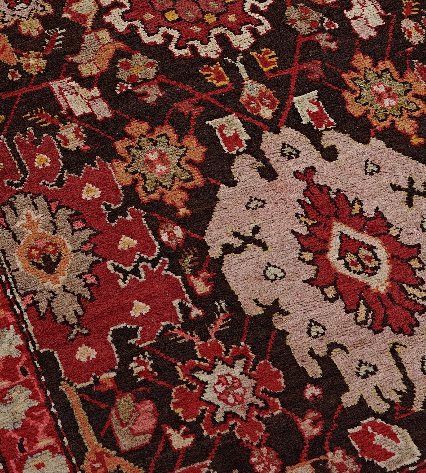 This antique, circa 1900, Karabagh runner has a chocolate-brown field with an overall design of polychrome bold palmettes linked by angular floral and palmette vine, in a brick-red narrow border of ice-blue floral sprays linked by angular floral